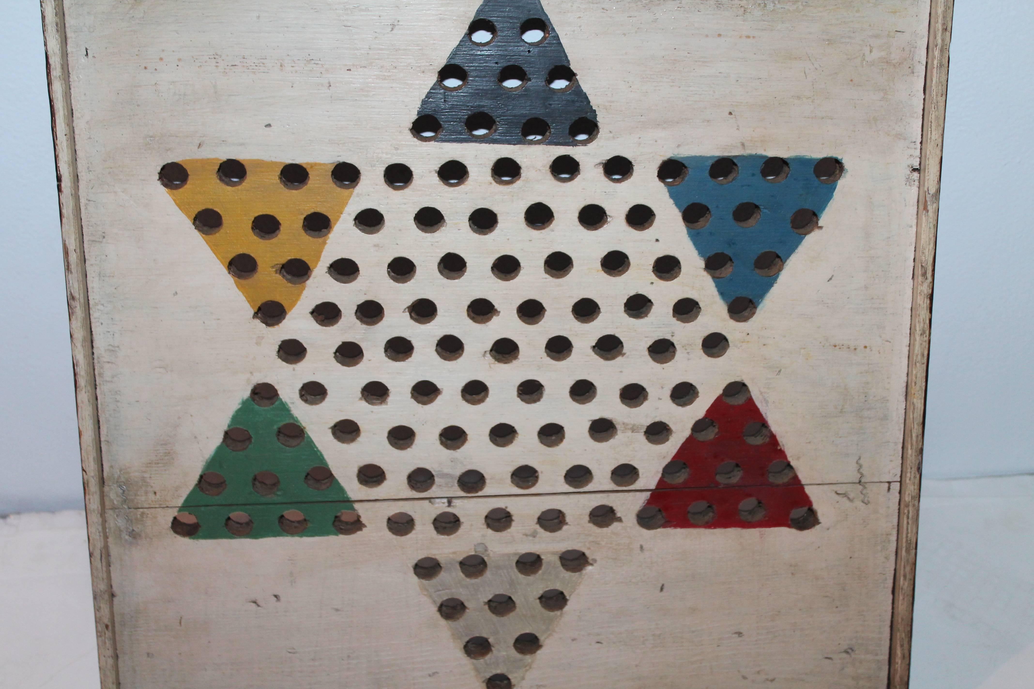 This folky Chinese checkers game board is in all original surface with a wonderful crackle paint. The back is in a coffee colored paint. Condition is very good. This is a handmade board.