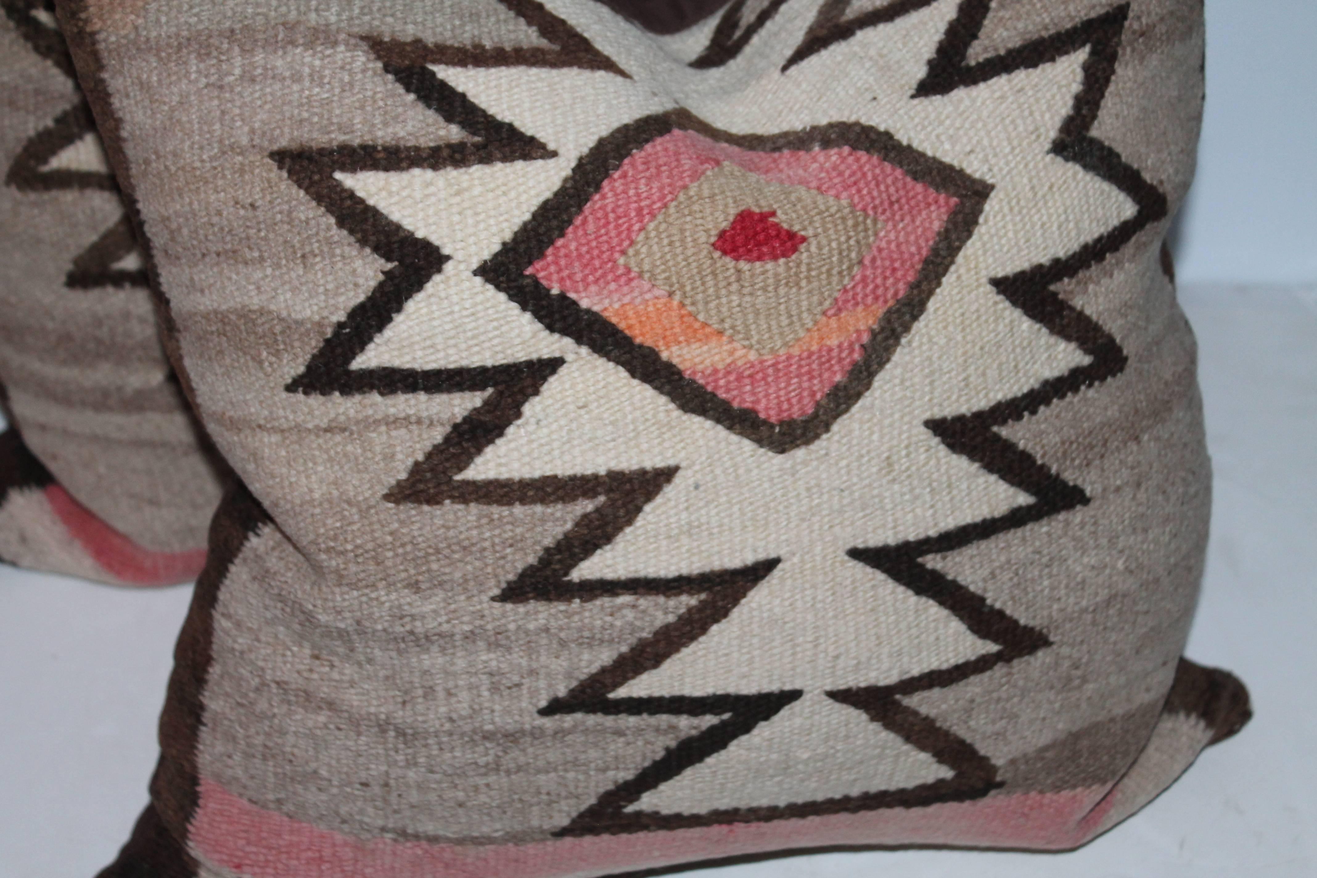 These nicely faded pair of Navajo Indian weaving pillows are made from one saddle blanket weaving. The condition are very good. The backing is in brown cotton linen.