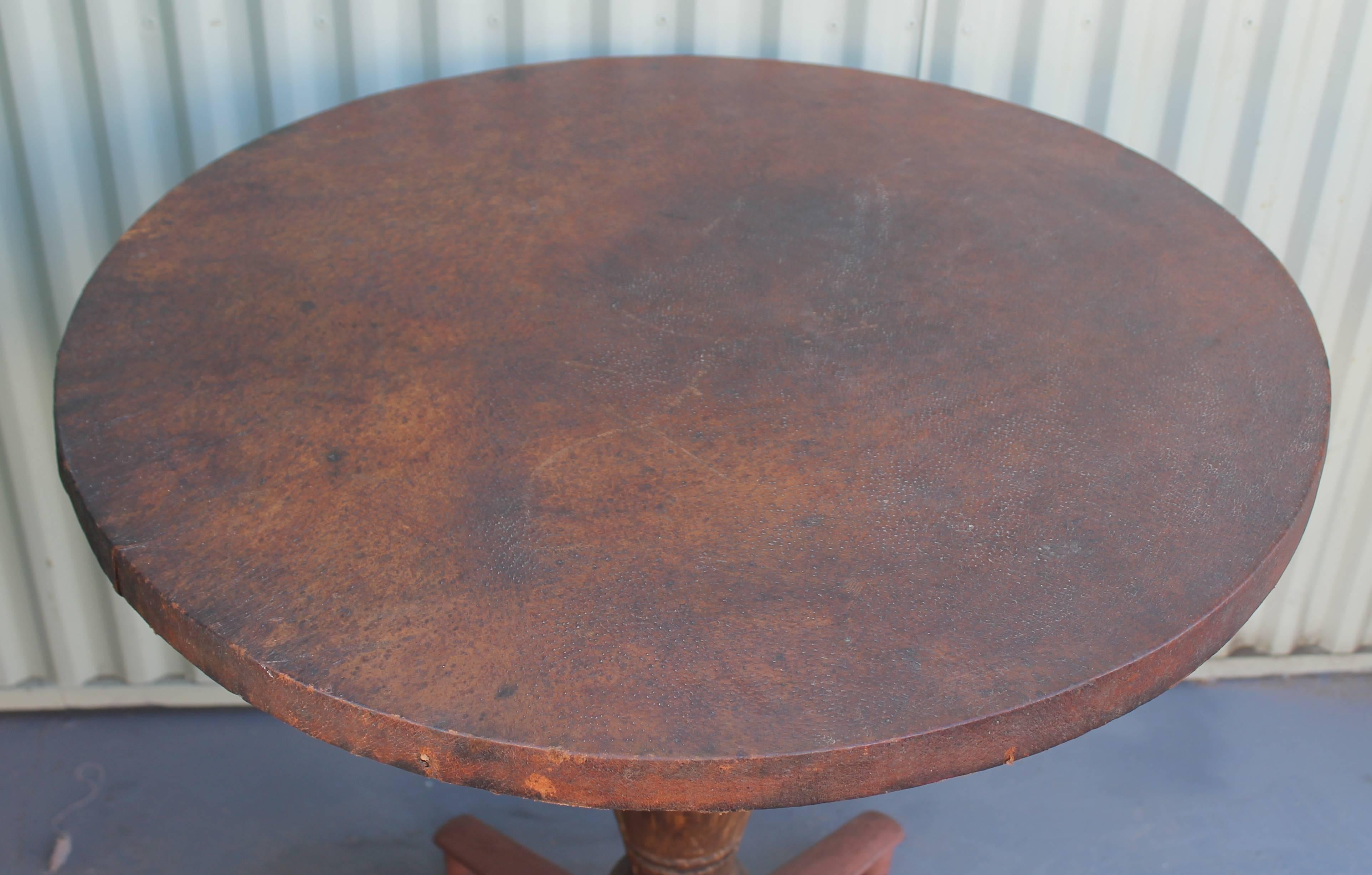 This fantastic game table could be used in a winery or bar, in just about any type of decor. It is constructed of a wood top and wood base with original painted iron feet. The condition is very good and sturdy.