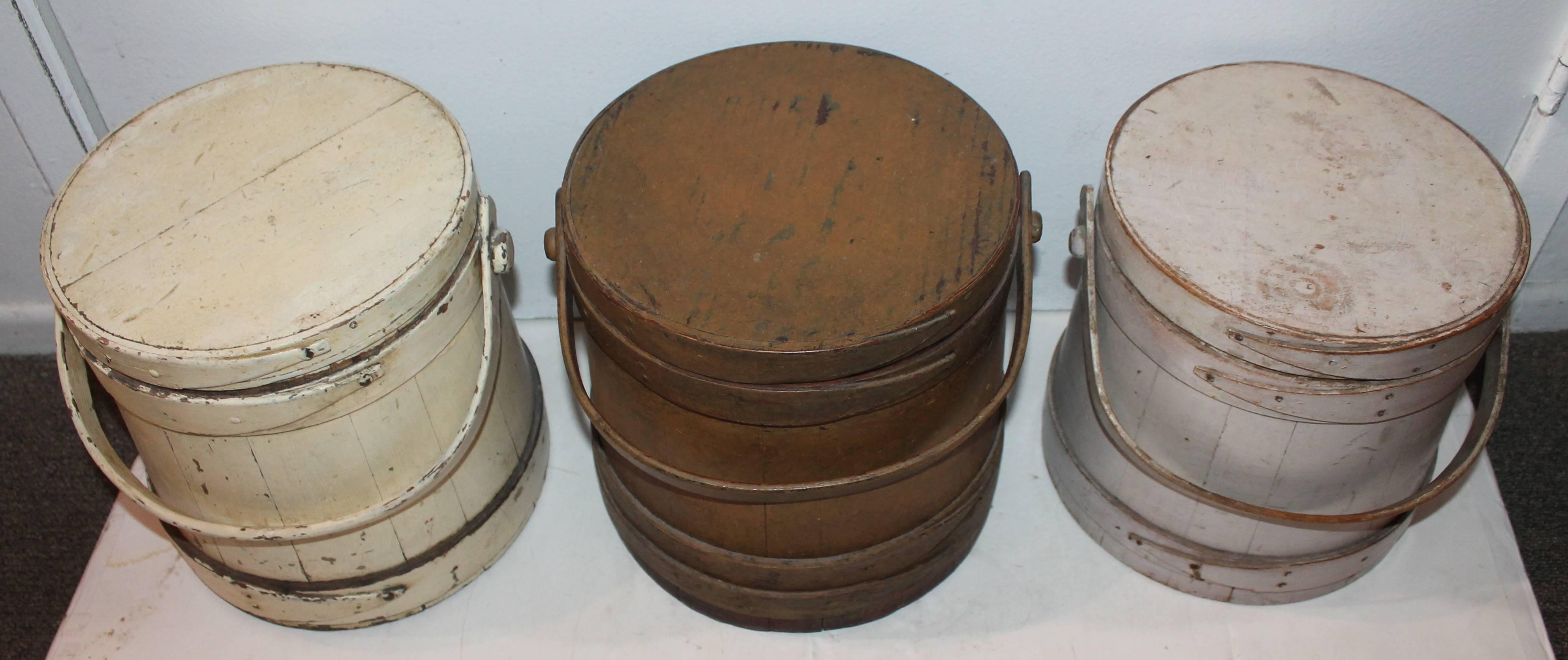 These three original painted 19th century furkins are in very good as found condition. The first to the left is in buttermilk colored paint. The second bucket is in a dirty mustard paint. Third bucket is in a blush or dirty off white surface. All