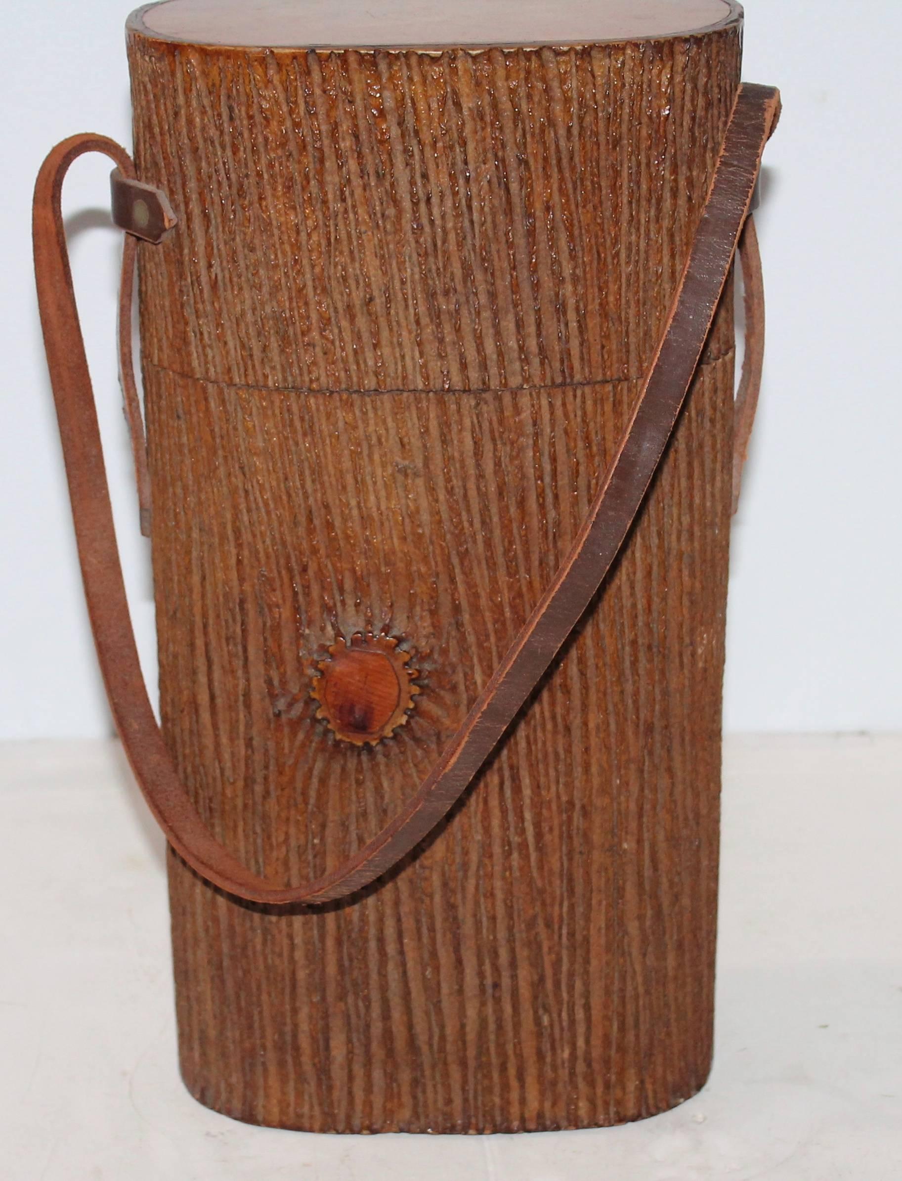 This large handmade leather and wood bark covered shoulder bag or humidor has a leather strap and wood top and base. The entire bag is covered in a bark and wood notts. The condition is very good. It is also covered in the original varnish surface.