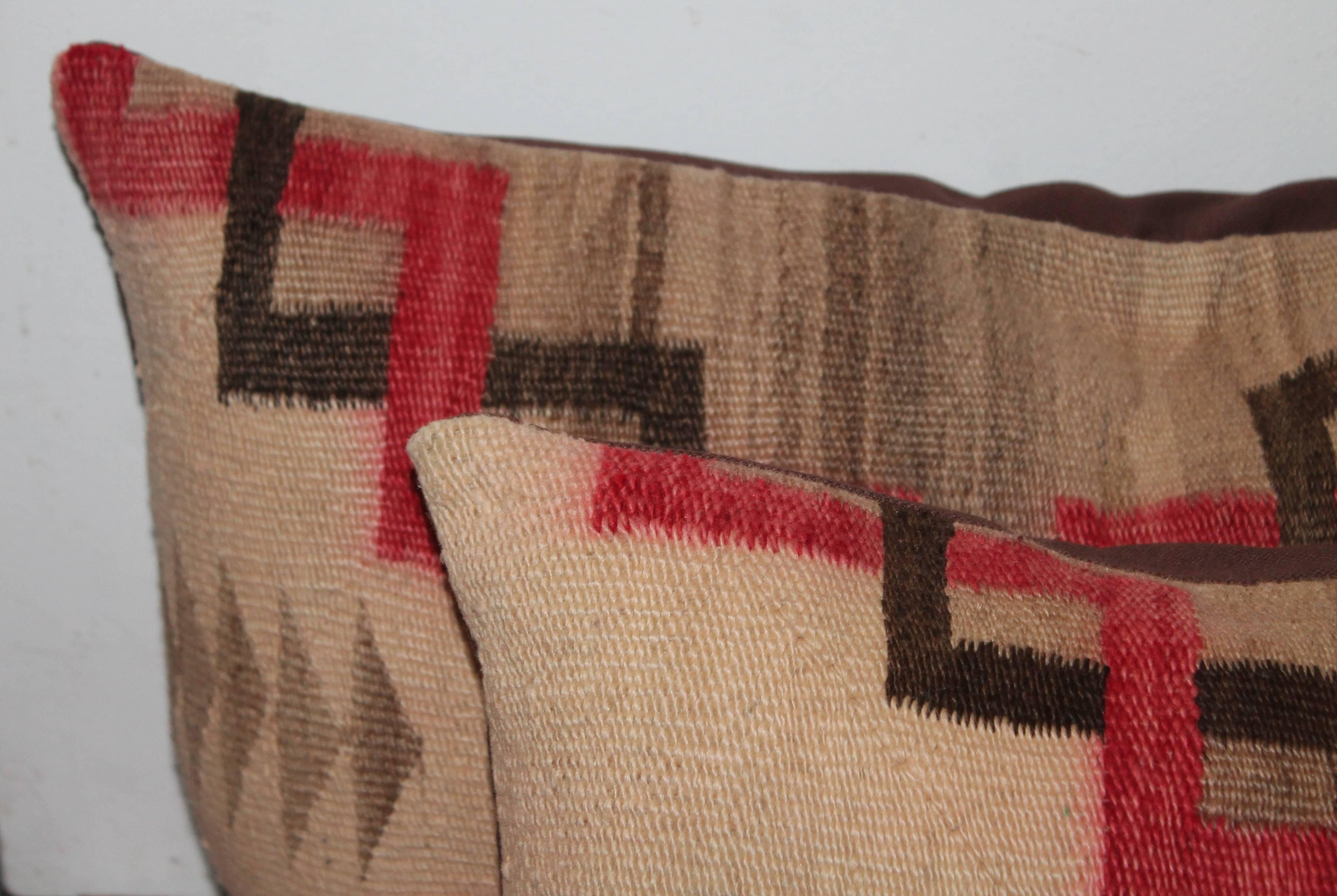 This pair of aged and faded geometric weaving pillows are in good condition with slight fading throughout. Minor wear.