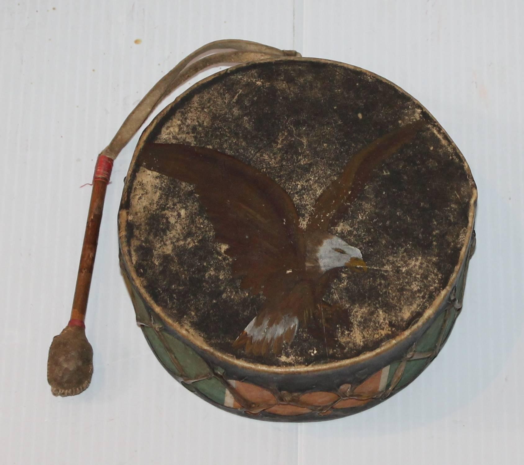 This fantastic rarity is in all original painted surface with the original handmade drum stick attached. The top of the drum has a painted eagle and the base has a coat of worn original black paint.