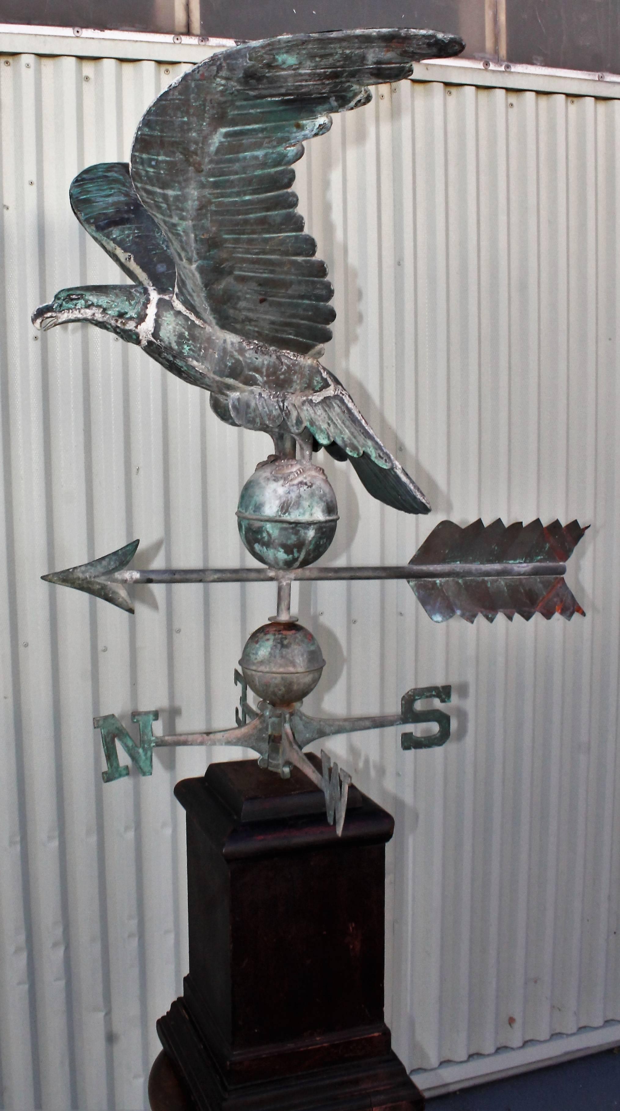 19th century monumental full body copper eagle weather vane in good condition. The patina surface is really great the base has the original Directional siting on a large painted pedestal. This eagle was found in New England. Can be removed from wood