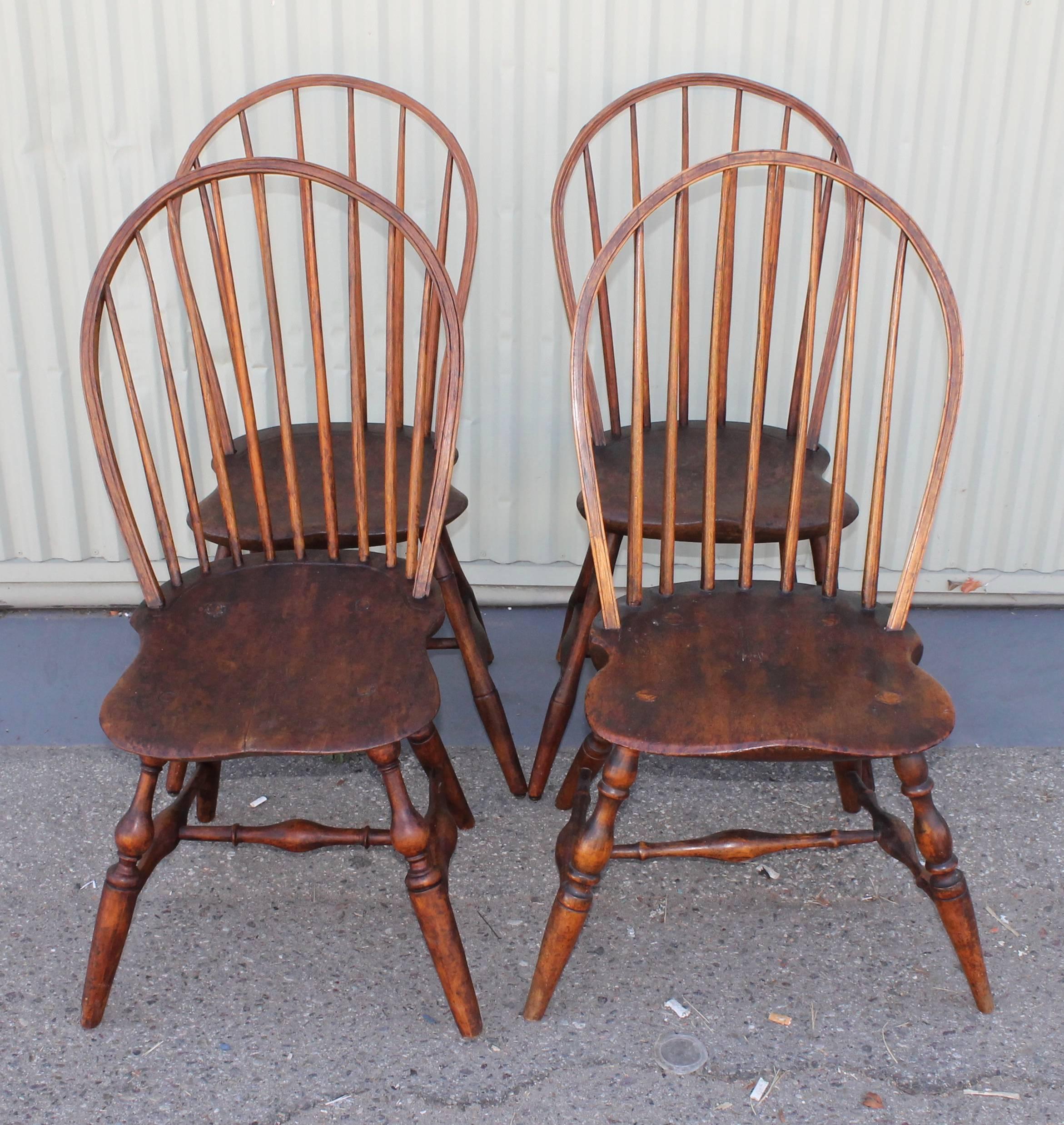 This set of four Windsor chairs are all in great condition and are very similar in design and patina. Two of the chairs have turned legs and two have bamboo turnings. These bow back Windsors are in great as found condition.