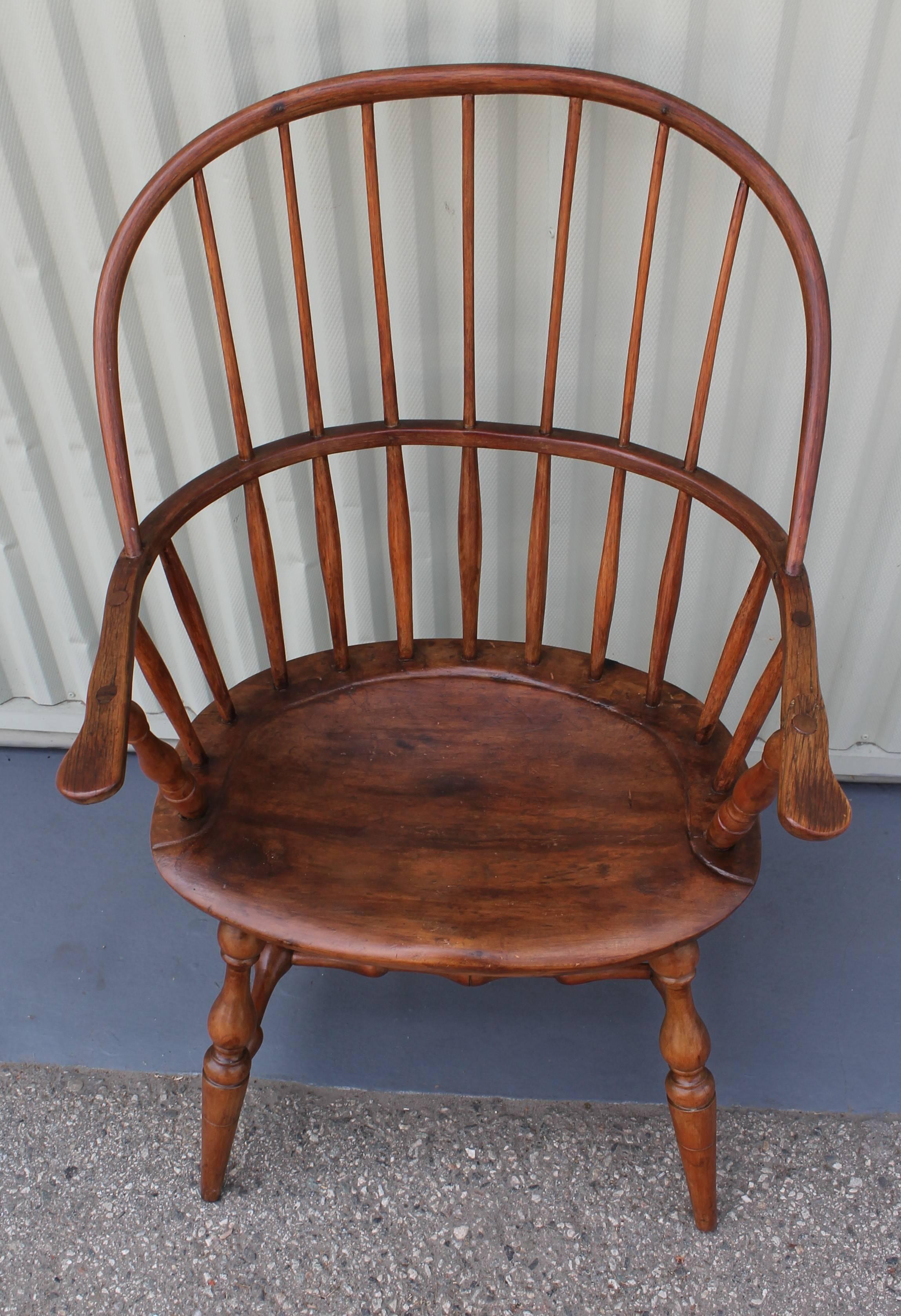 This New England saddle seat and extended arm windsor chair has a old repaired seat and seat height is 17