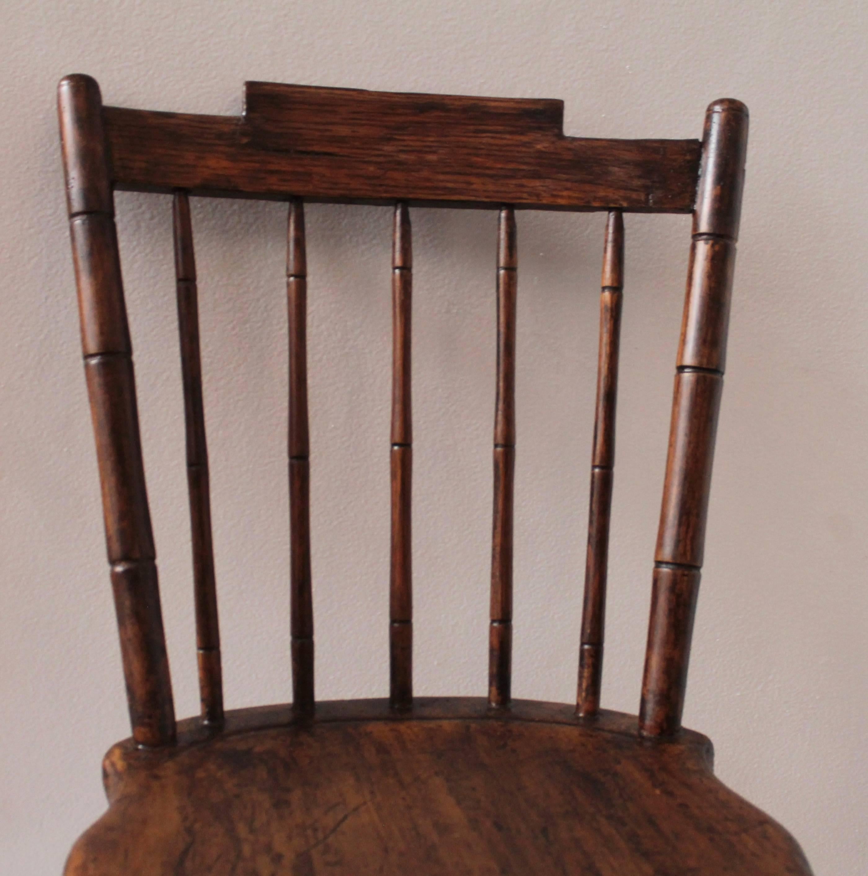 Early 19th century painted child's windsor chair in good condition. The chair has a second generation painted surface.