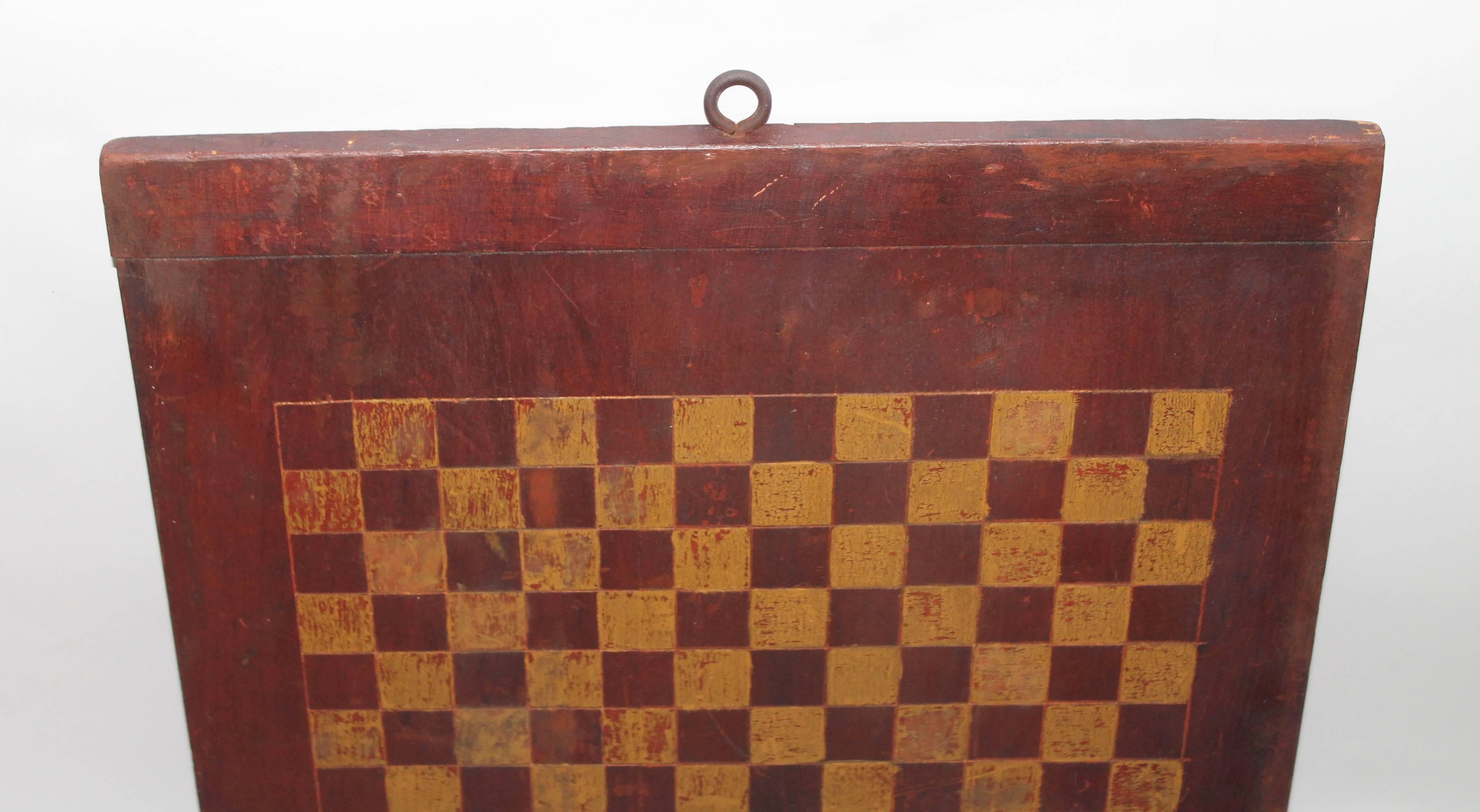 This 19th century mustard and red painted game board with postage stamp scale blocks is in good condition. The board has bread board ends and painted on both sides.
