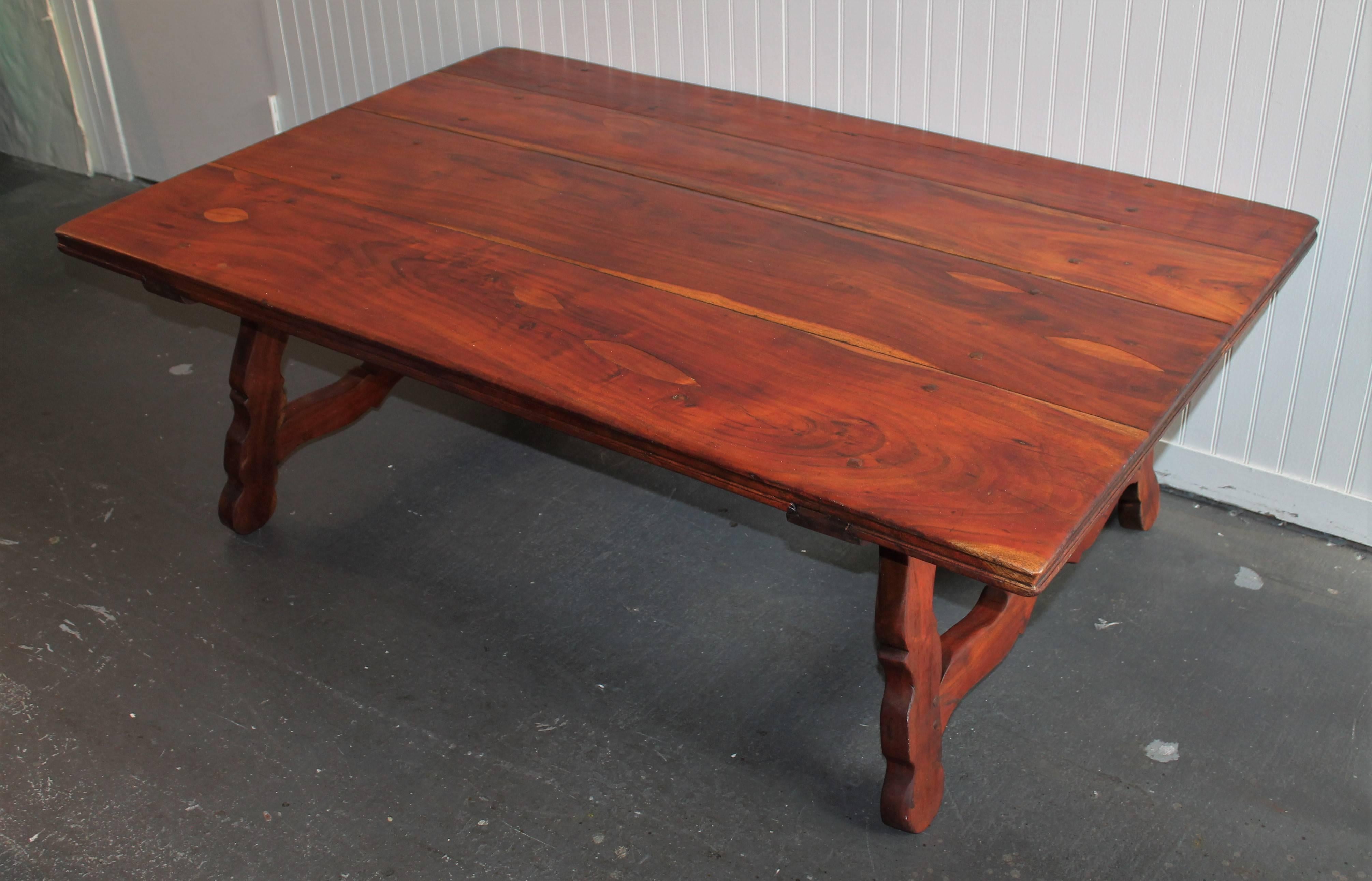 The heavy walnut Spanish style coffee table is in great condition. The construction is dovetailed base and early wood pegs. The form is the best.