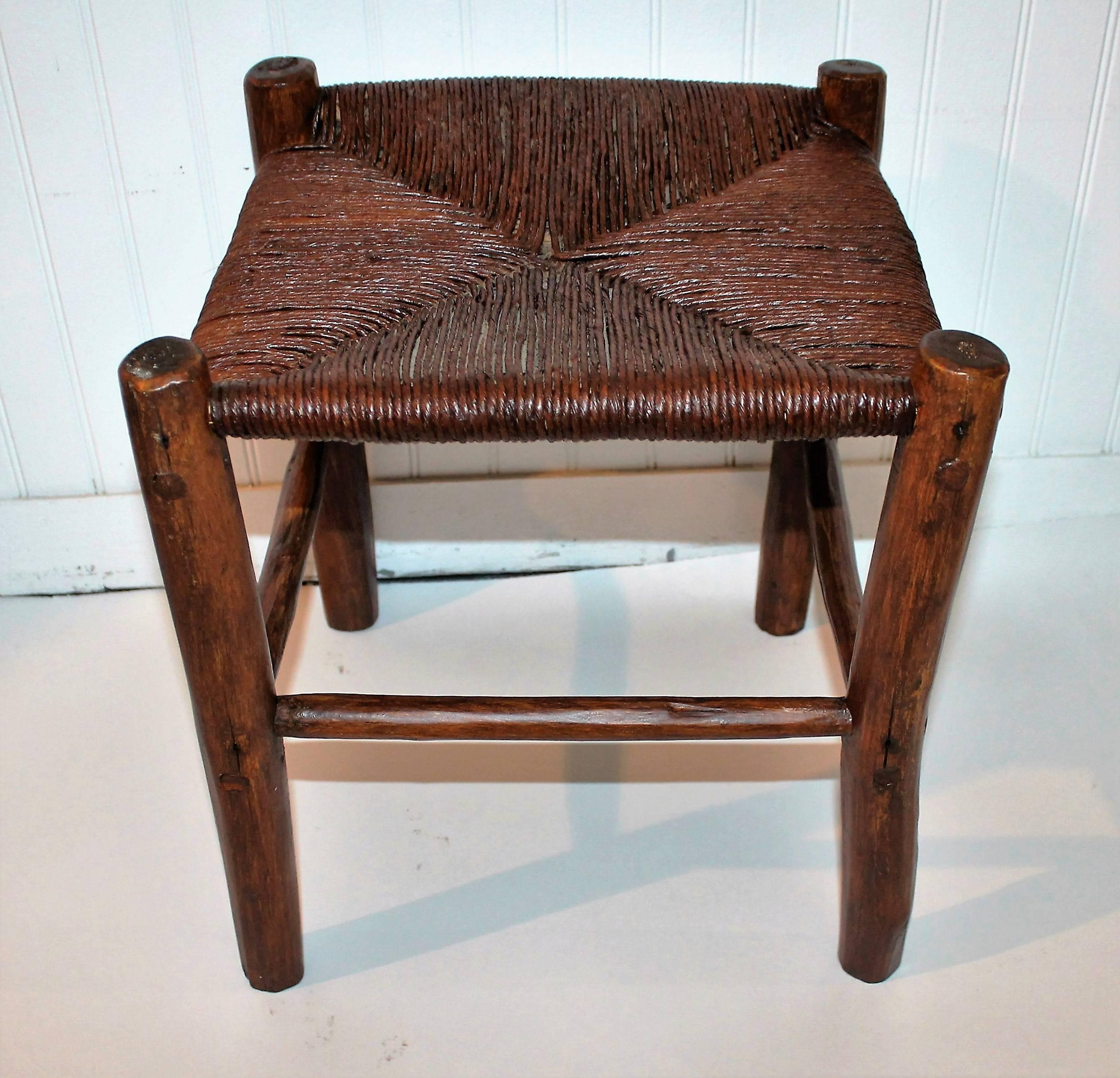 This handmade hickory foot stool is in great and sturdy condition. The hand woven stool is pegged and has a stained surface.