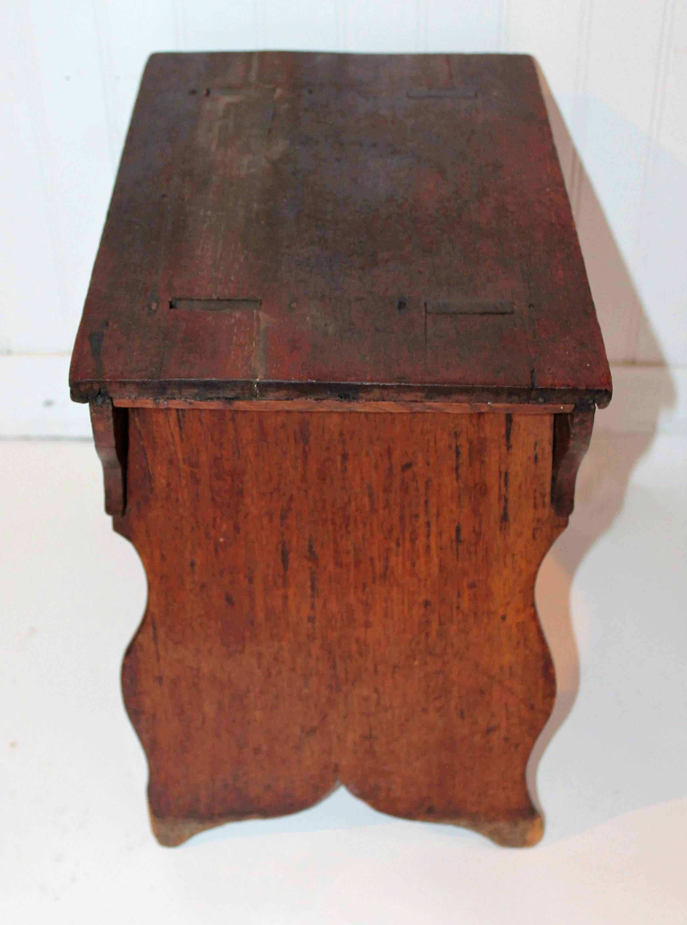 This fancy cut-out country stool is mortised through the top and wonderful cut-out. The small drawer has an early original brass pull. Minor repairs and sturdy condition.