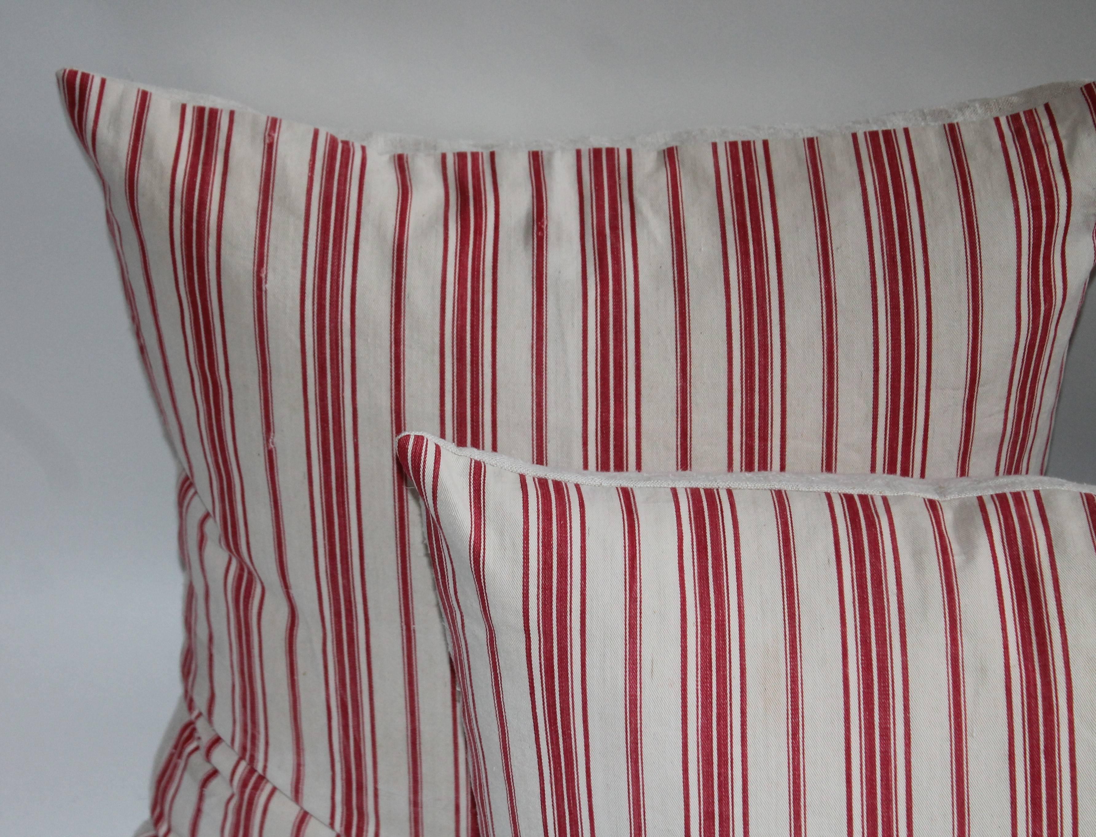 These amazing red ticking pillows are a beautiful find. This beautiful trio/pairs of American ticking pillows have been professionally cleaned. These pairs all have zipper enclosures with down and feather inserts.

The two pairs to the left of the