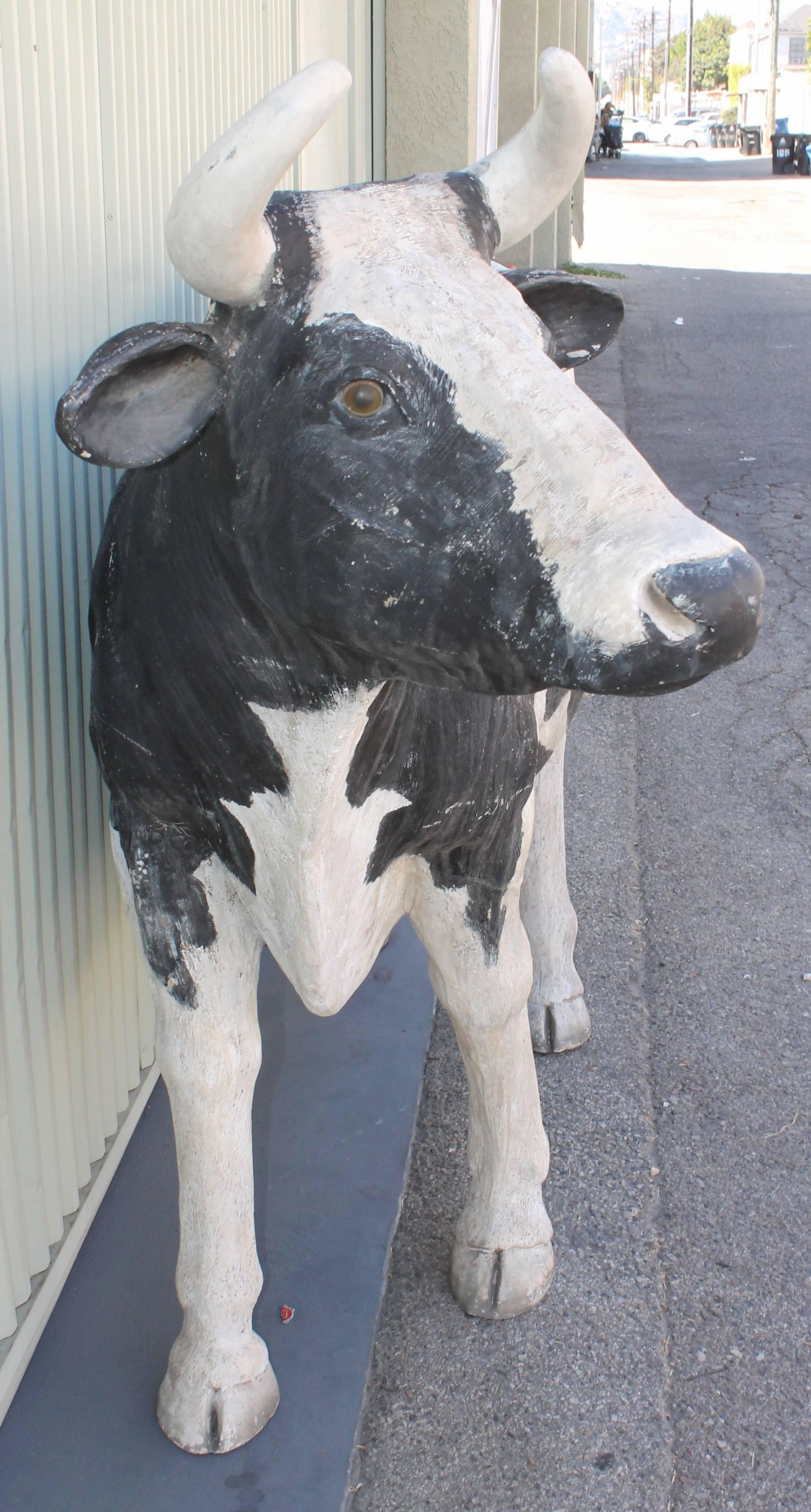 This folky painted fiberglass full body cow comes from a outdoor dairy farm sign. This can be outdoors or a cow garden element. The condition is good with real plastic eyes and wear consistent from age and use. Was sprayed with outdoor protector.