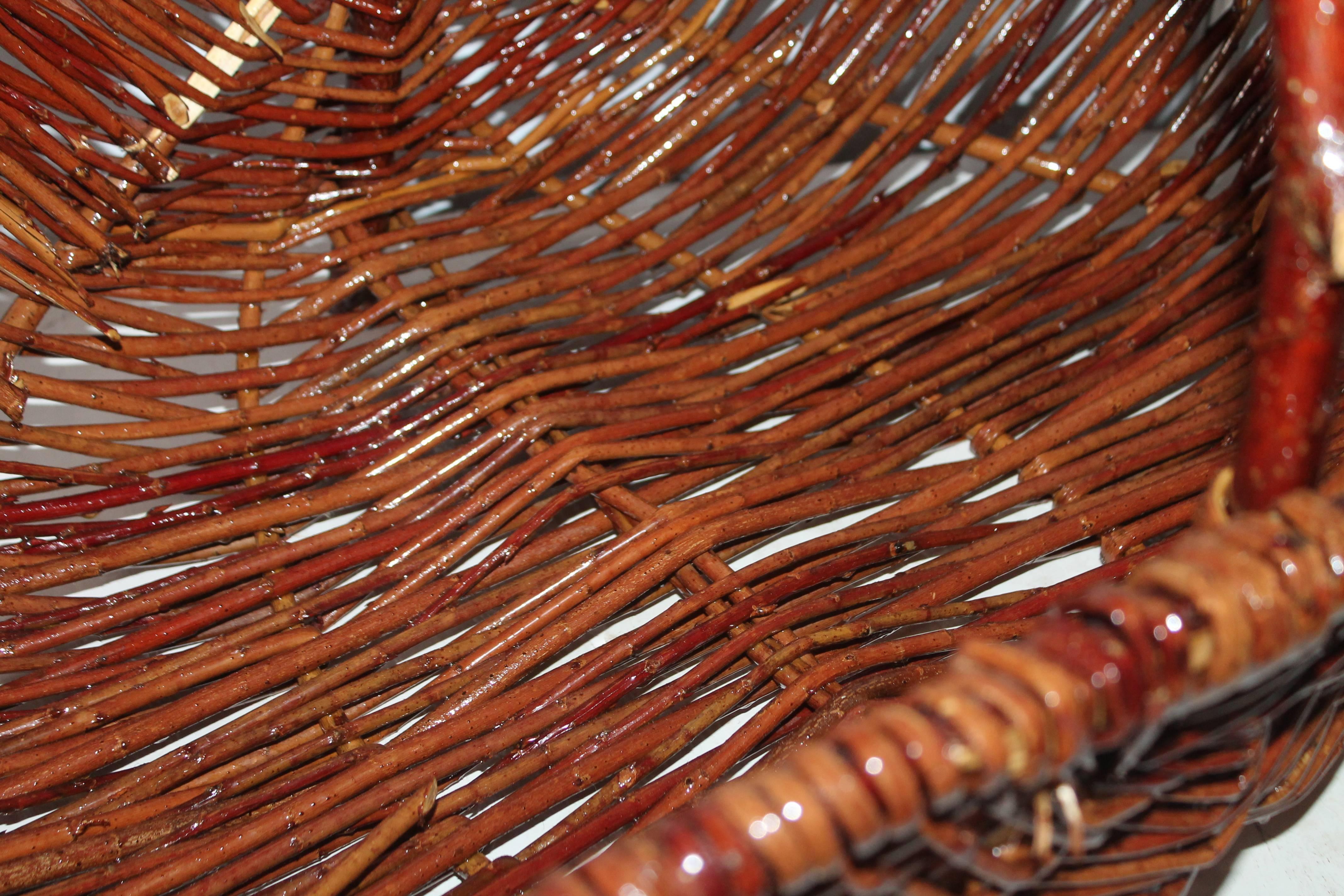 This large hickory basket is in good condition with a coat of varnish on it. It sits on the ground with two feet or on tabletop. The condition is very good.