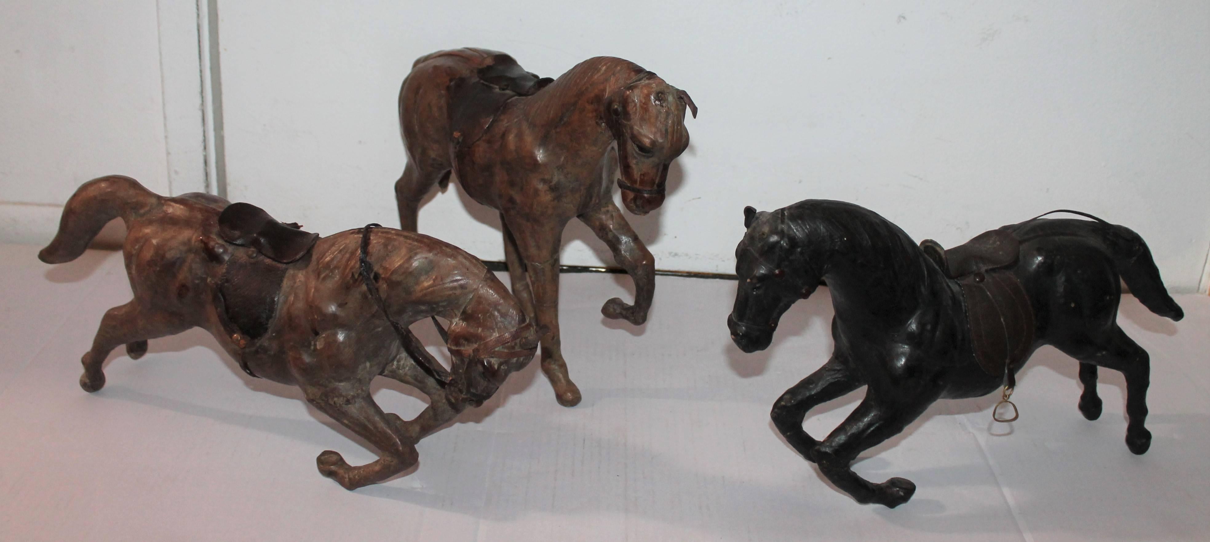 These three horses are hollow body leather horses probably made in Mexico.
 They are unsigned. One has a missing ear. The condition are very good and they can stand on their back legs or on all four. Horse on left: 18 x 8 x 4.
Middle: 16 x 7 x