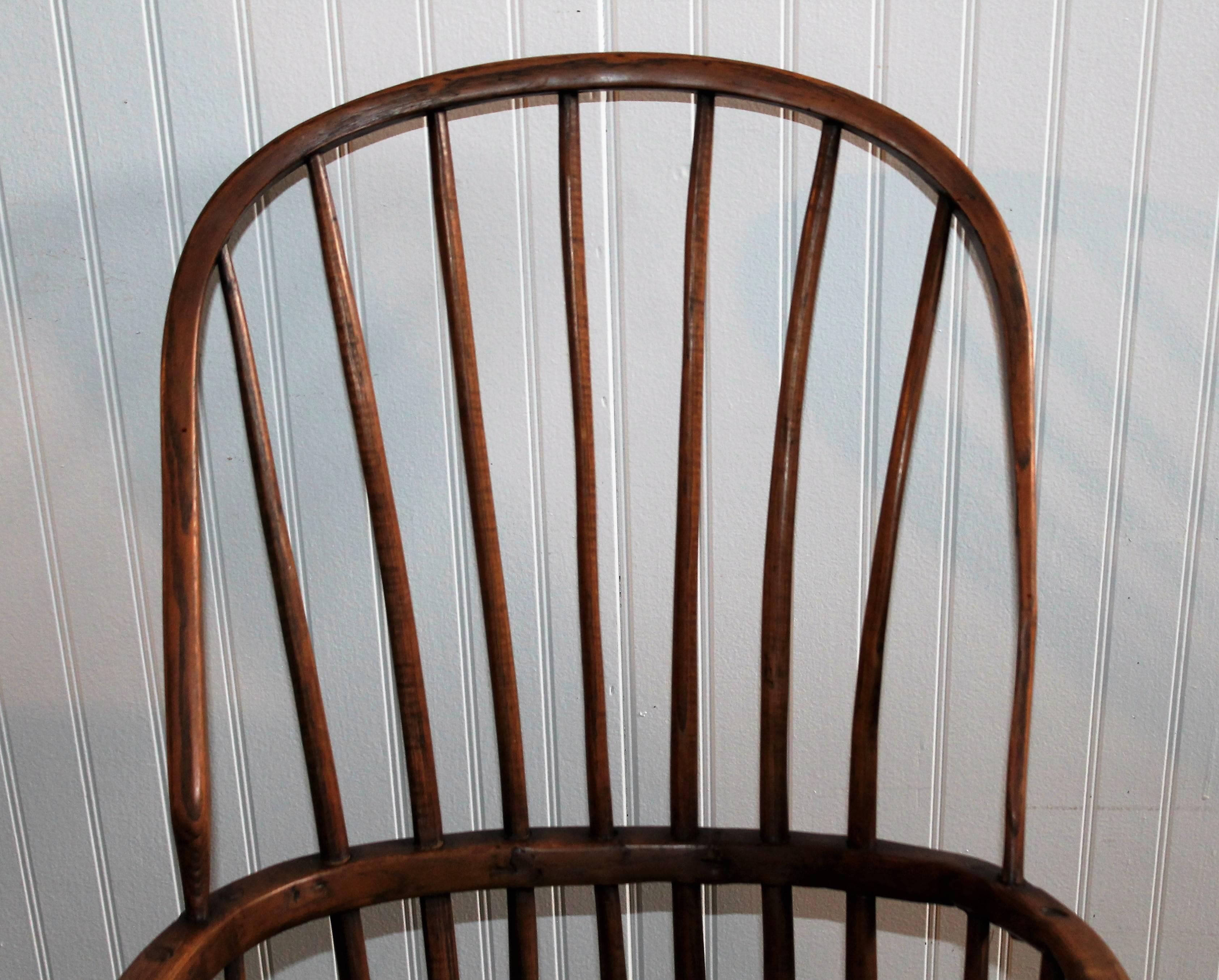 This extended arm high back Windsor chair is in very good and sturdy condition. This wonderful bow back has a great untouched surface. The seat height- 14 in. The spindles are some what folky as it is clear that it is a hand-carved chair.