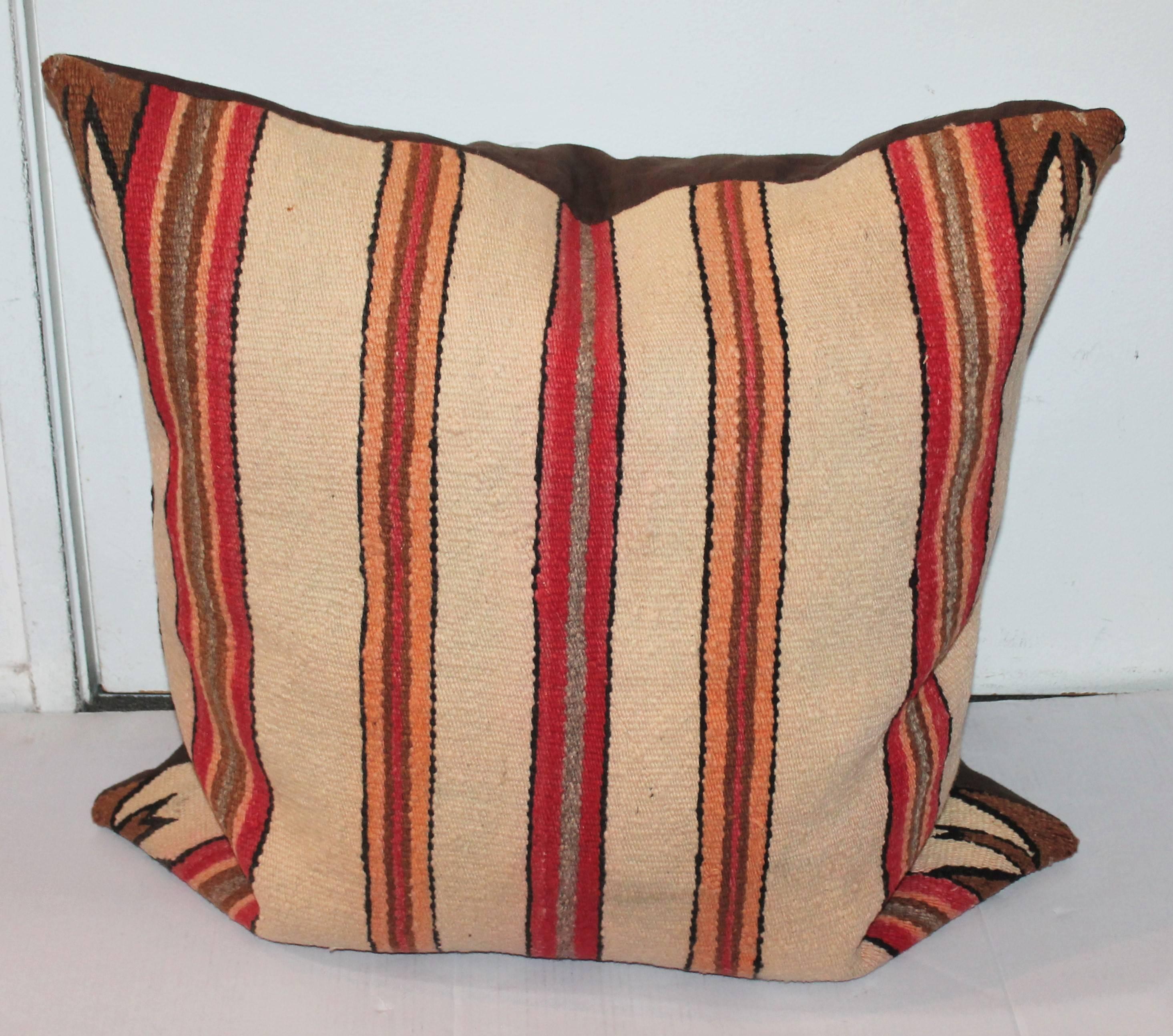 This early striped Navajo weaving bolster pillow has unusual saw tooth pattern in corners. The back is a dark chocolate cotton linen backing. The condition is very good with down and feather fill.