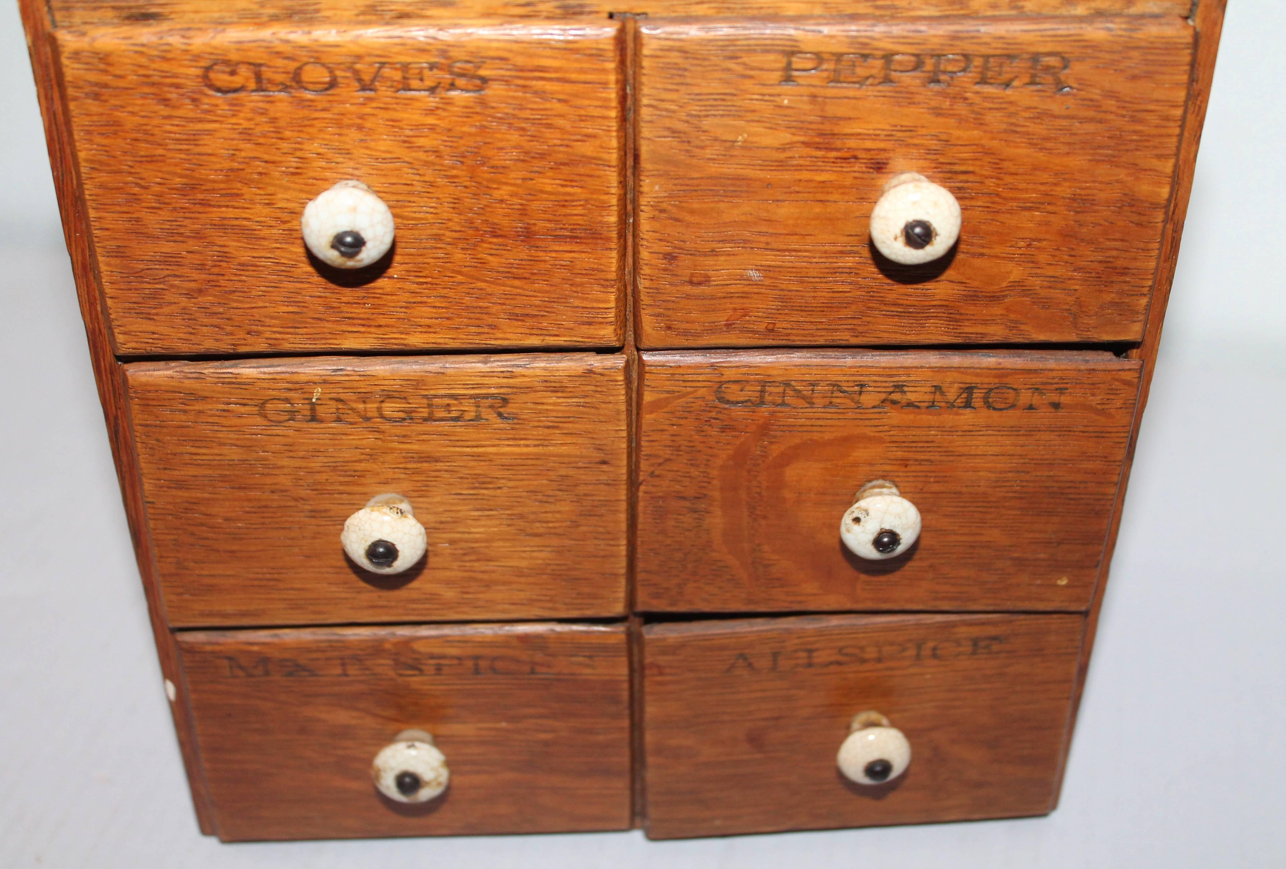 This 19th century oak counter or hanging apothecary spice box is in fine as found condition. The wear is consistent with age and use. The drawers are marked cloves, pepper, ginger, cinnamon, all spice, mxt spices. The porcelain knobs on the drawers
