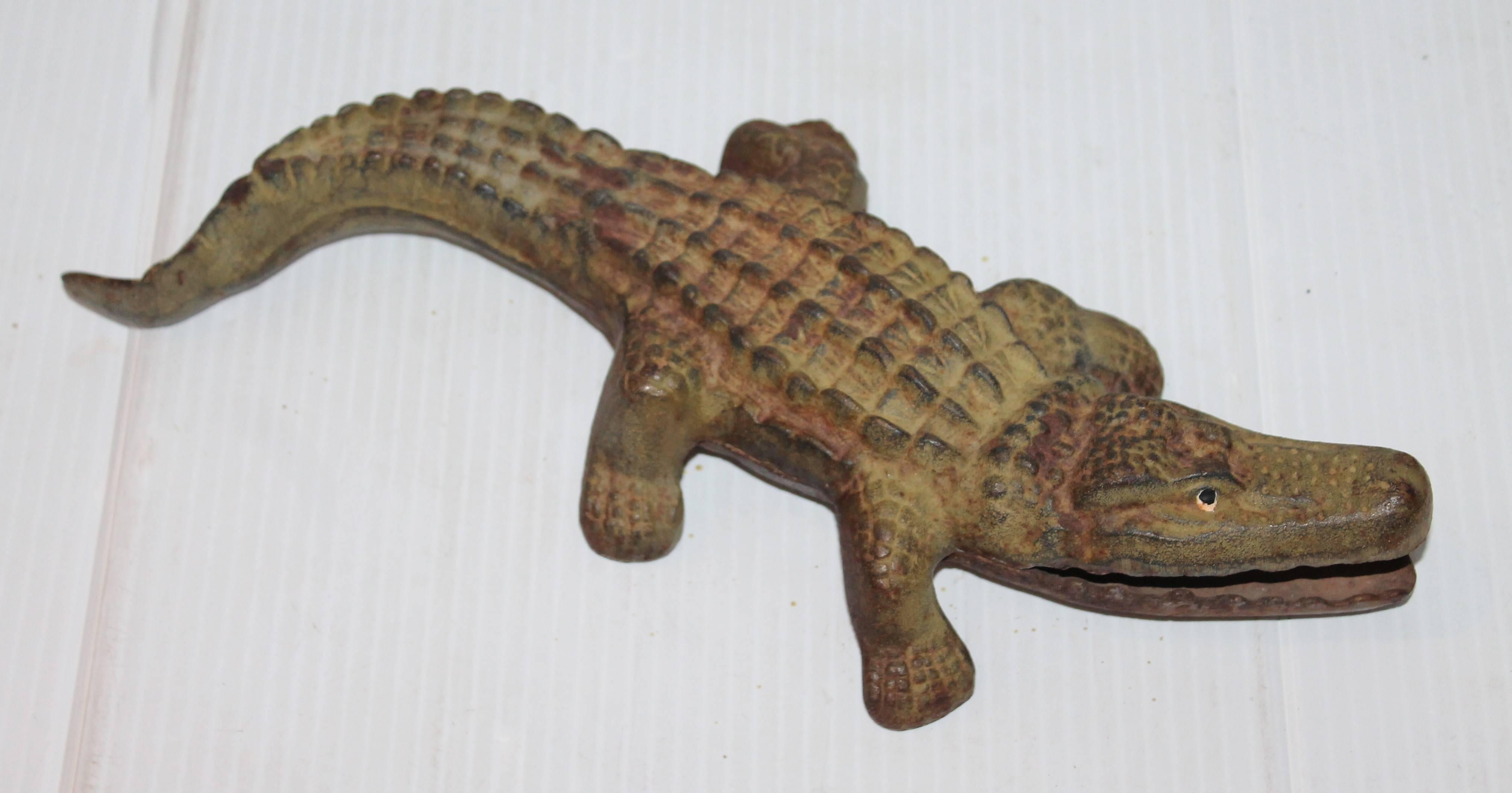 This fun cast iron alligator has a cram painted belly and sage green painted torso. The condition is very good. He has a lot of weight, like a door stop.