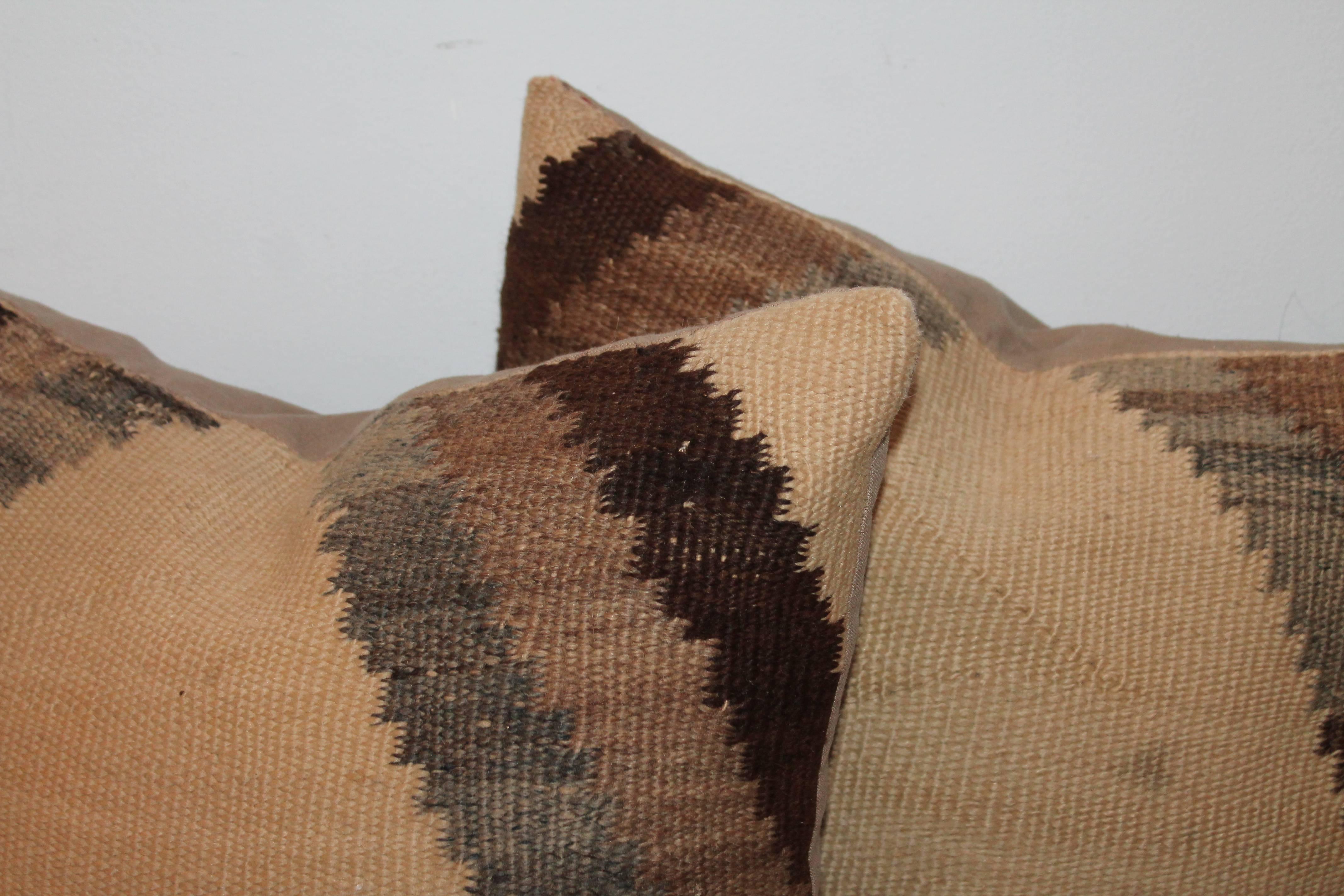 Pair of early brown and tan Navajo weaving pillows. These weaving pillows have the lazy lines and are in very neutral colors.