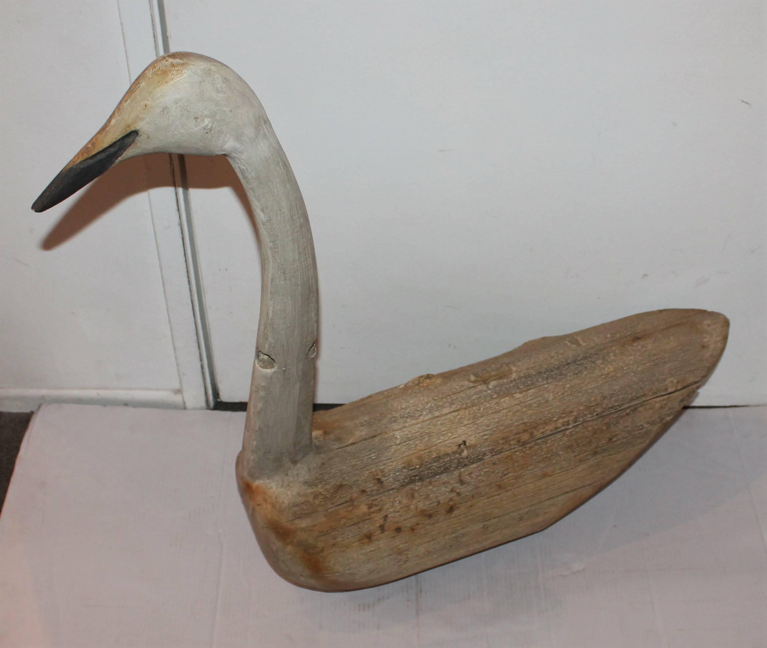 This amazing log goose decoy is made from a log and the neck and head are hand-carved to fit the log. There is amazing patina to the body and neck areas of this decoy only created by age and use. There are incisions in the neck and to the body where