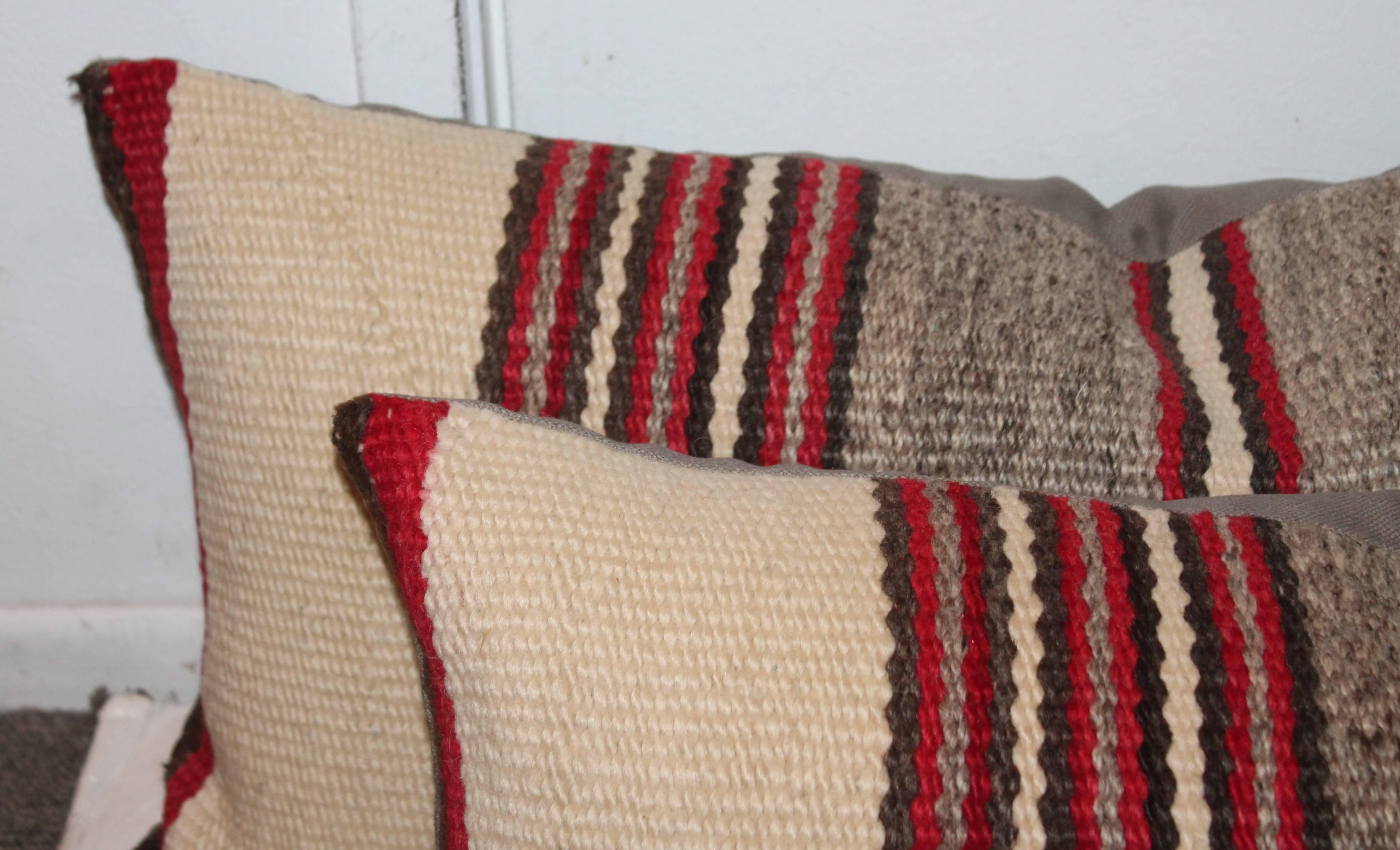 This fine and simple Navajo striped weaving bolster pillows are in great condition and sold as a pair. The backing is in a grey cotton linen.