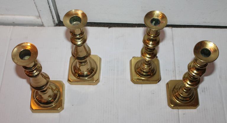 These beautiful polished brass 19th century candle stick holders were found in New England and are in fine condition. Sold as one collection.