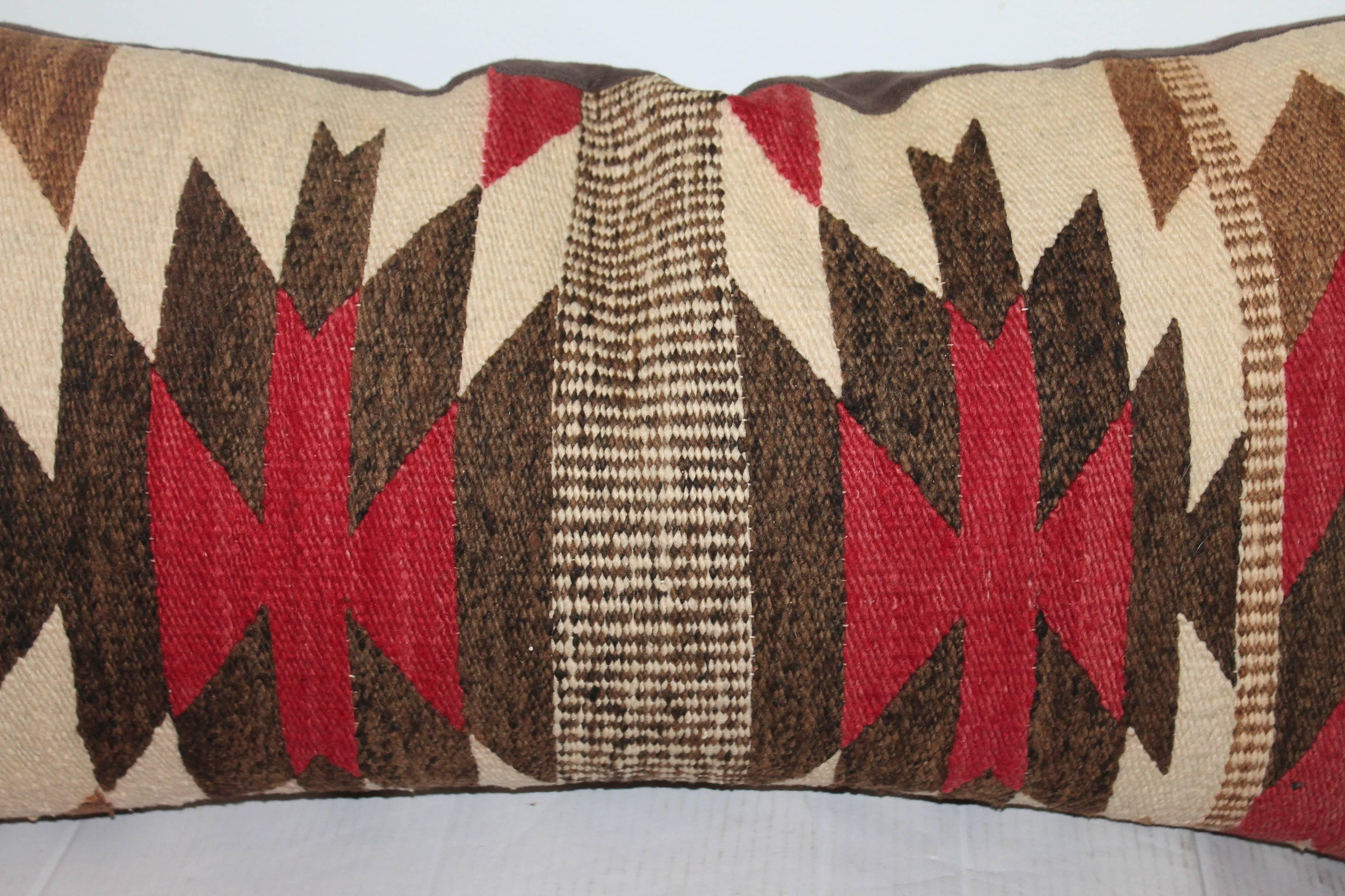 This early and graphic Navajo saddle blanket weaving bolster pillow is in wonderful condition with a brown cotton linen backing. Insert is down and feather.