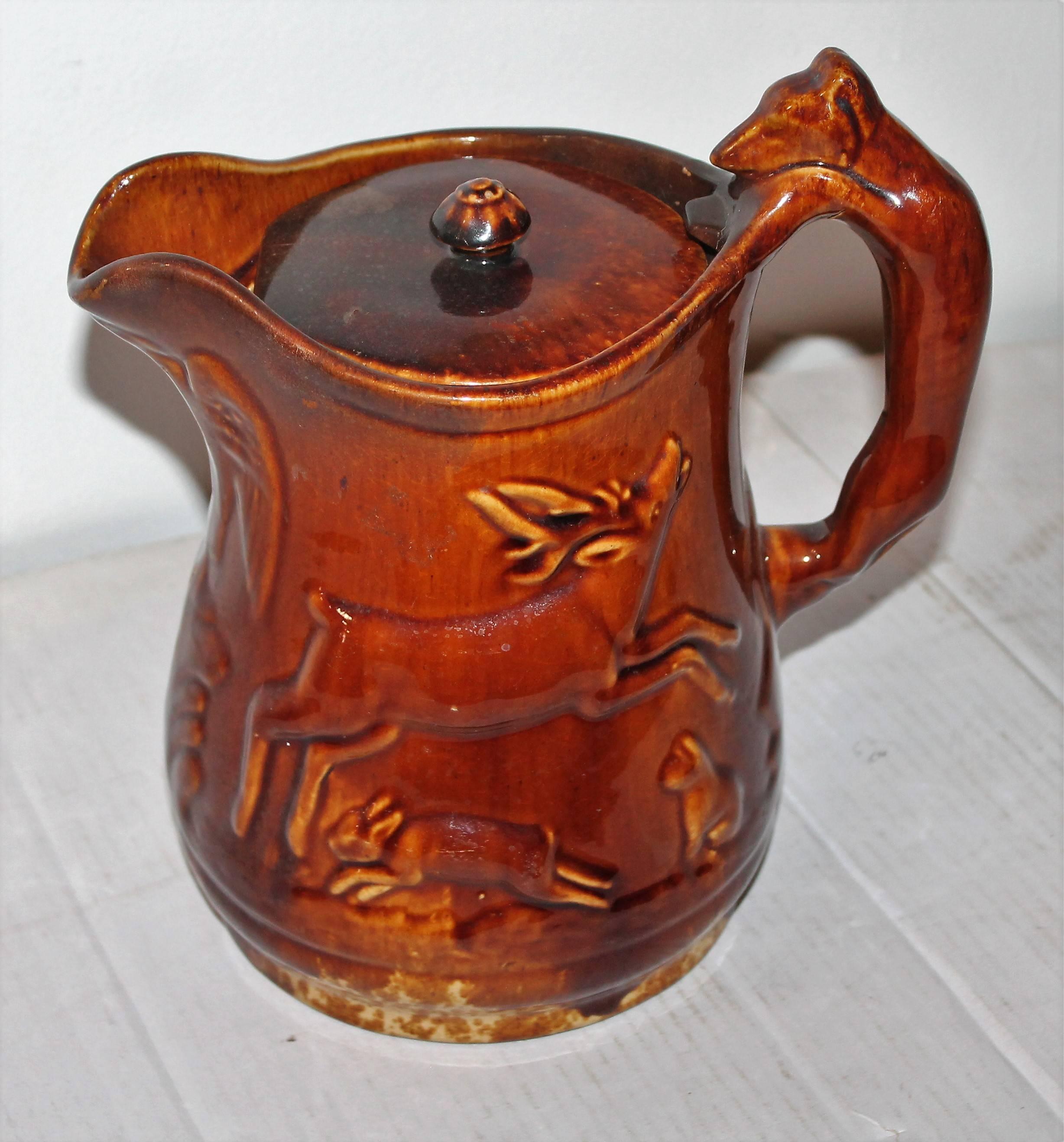 This fine example of Rockingham / Bennington 19th century pottery is in mint condition and has the original lid. There is an American eagle on the spout and dogs, deer, rabbits, cats and a turkey. The handle is a dog, possibly a fox terrier. So very
