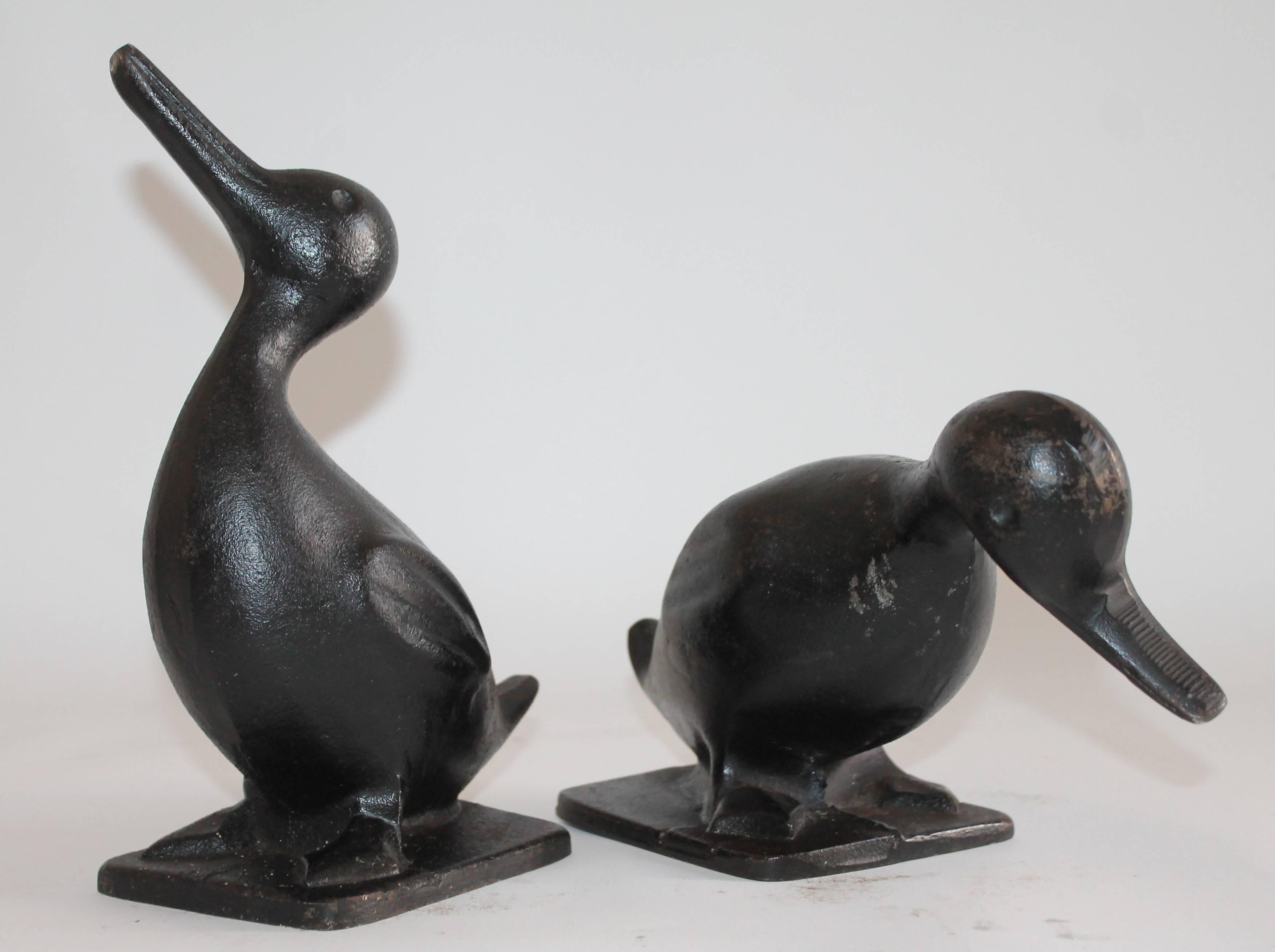 These fun and folky original black painted cast iron duck door stops are in great as found condition. These guys are very heavy. Great as a pair.