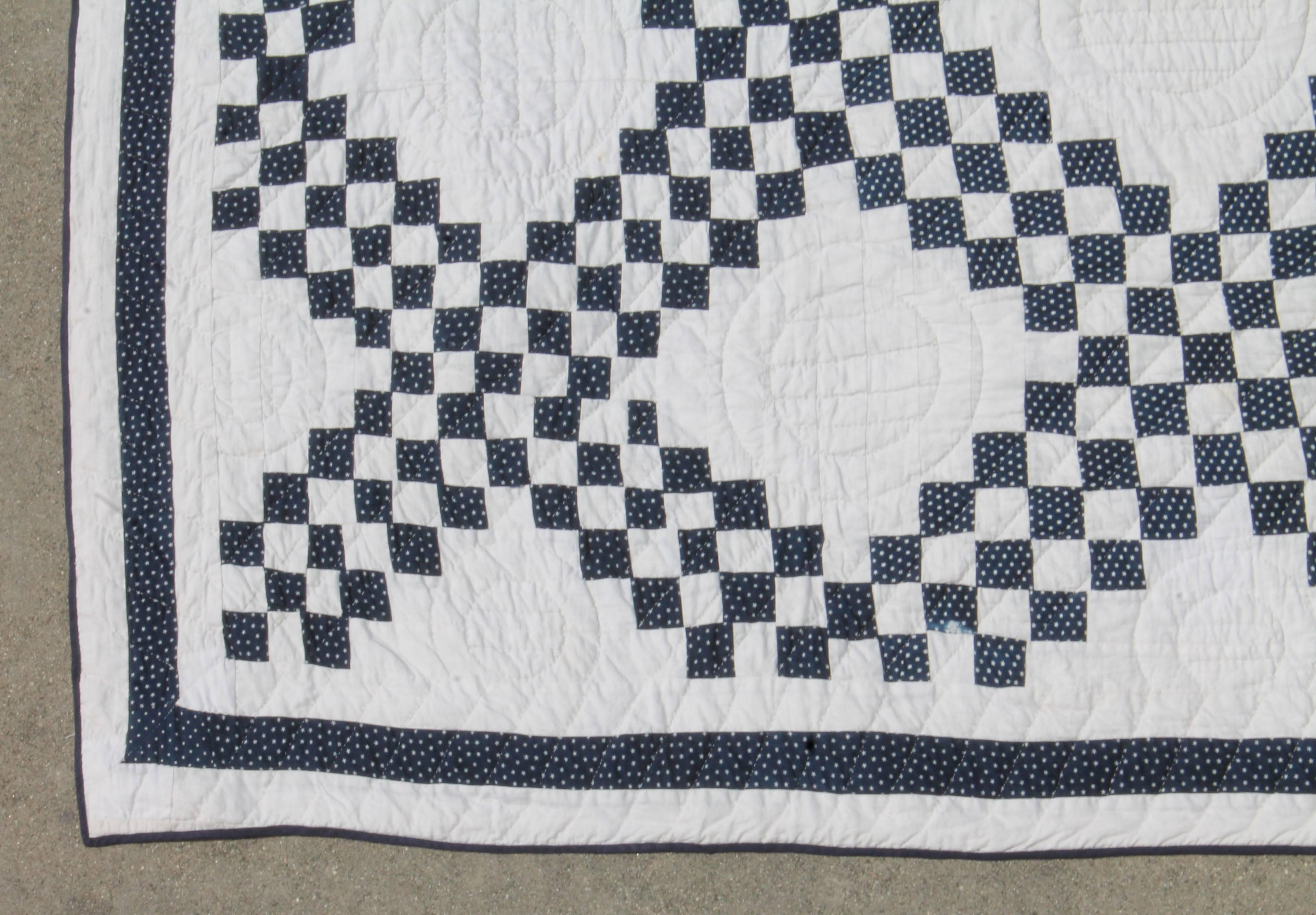 This finely pieced blue and white postage stamp quilt is in great condition. It is a triple Irish chain quilt with an inner border.