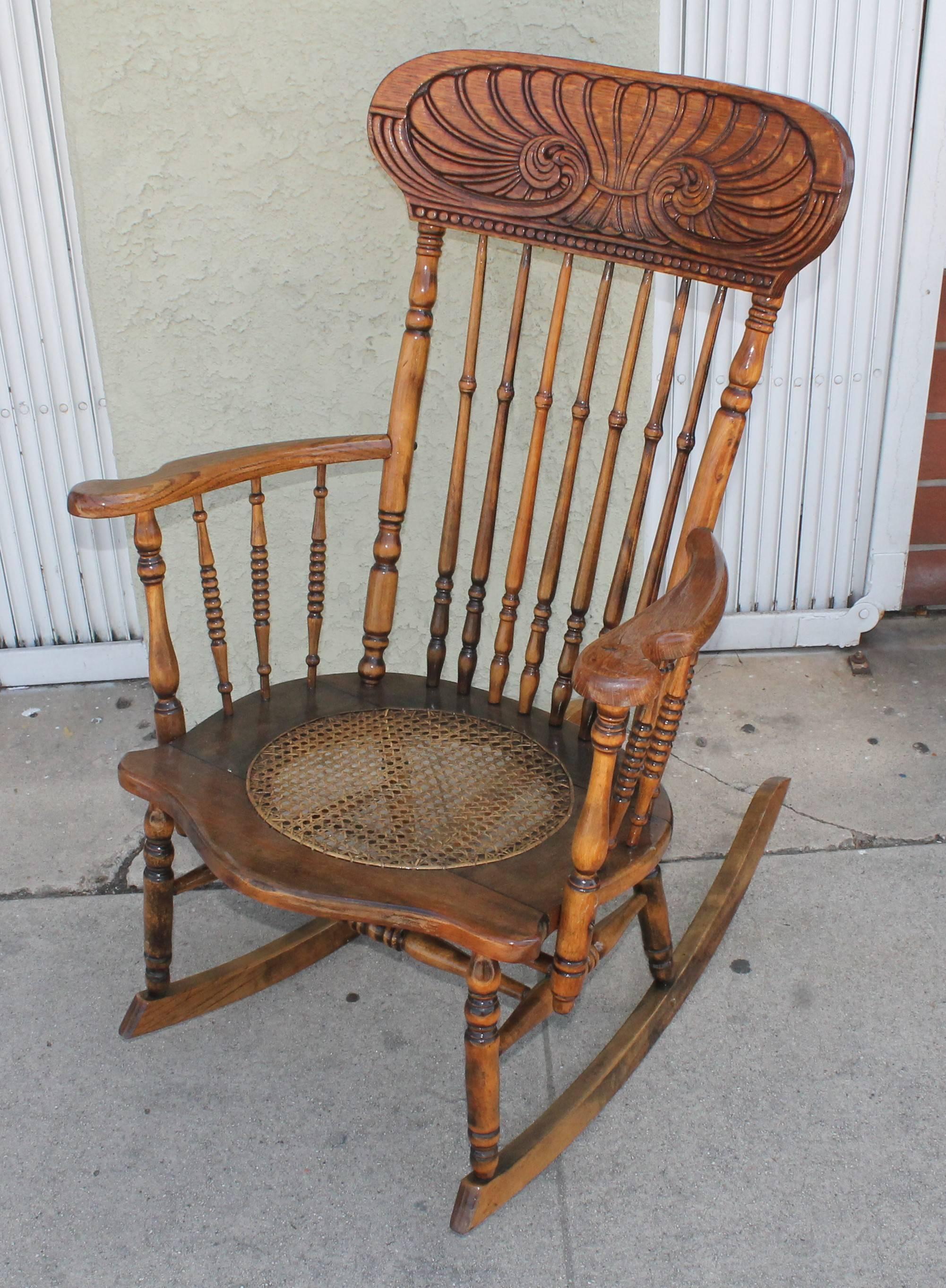 This fine folky press back rocking chair has a wonderful mellow patina and is in fine sturdy condition. The cane seating has been newly finished. There is a coat of all weather protector on this rocking chair. Was on a front porch of a cabin in the
