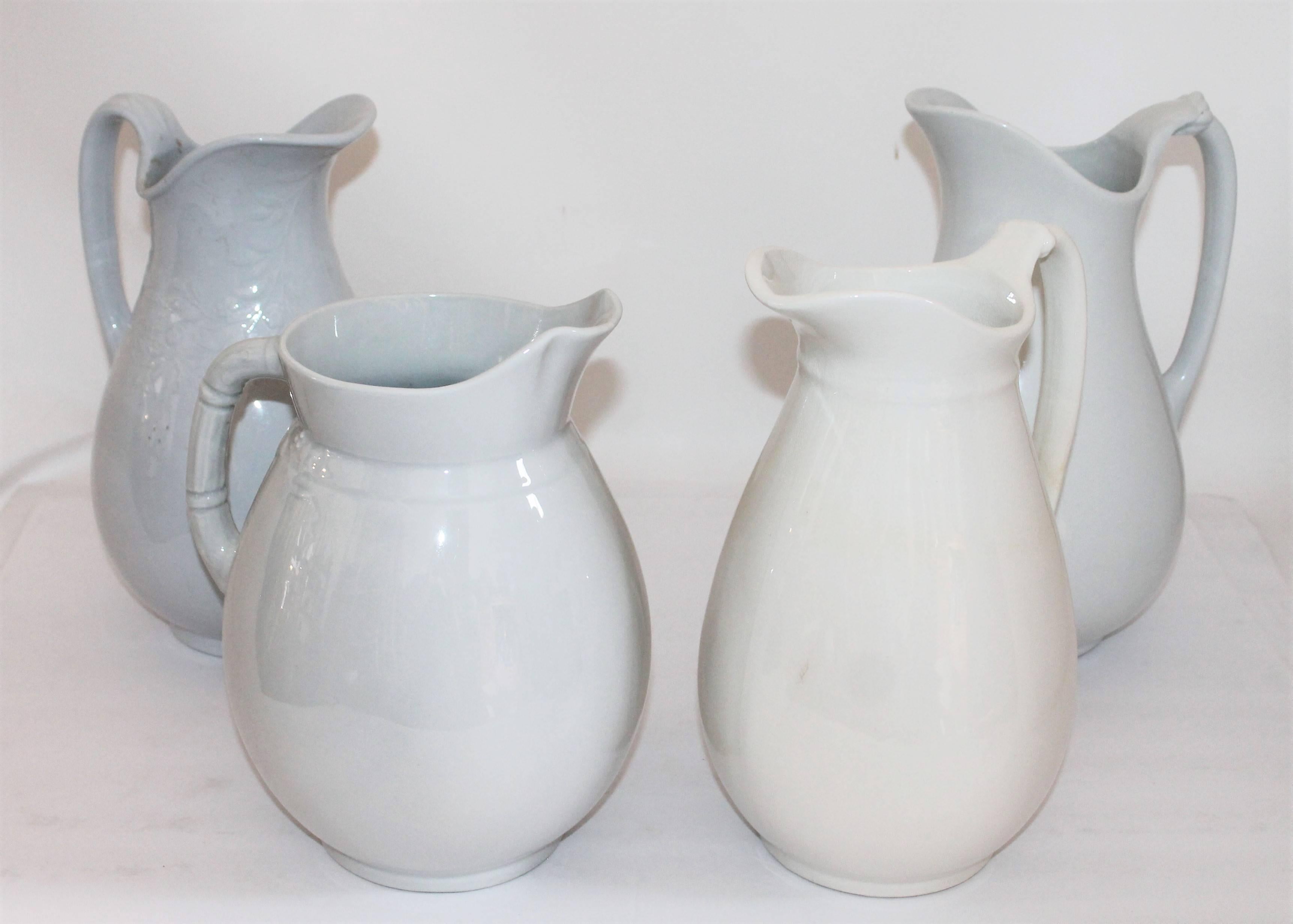 A collection of four 19th century iron stone pitchers. These pitchers have minor wear consistent with age and use. There are a few repairs on some of the pitchers some within the pitchers.
The pitchers measurements are given in a radius of or