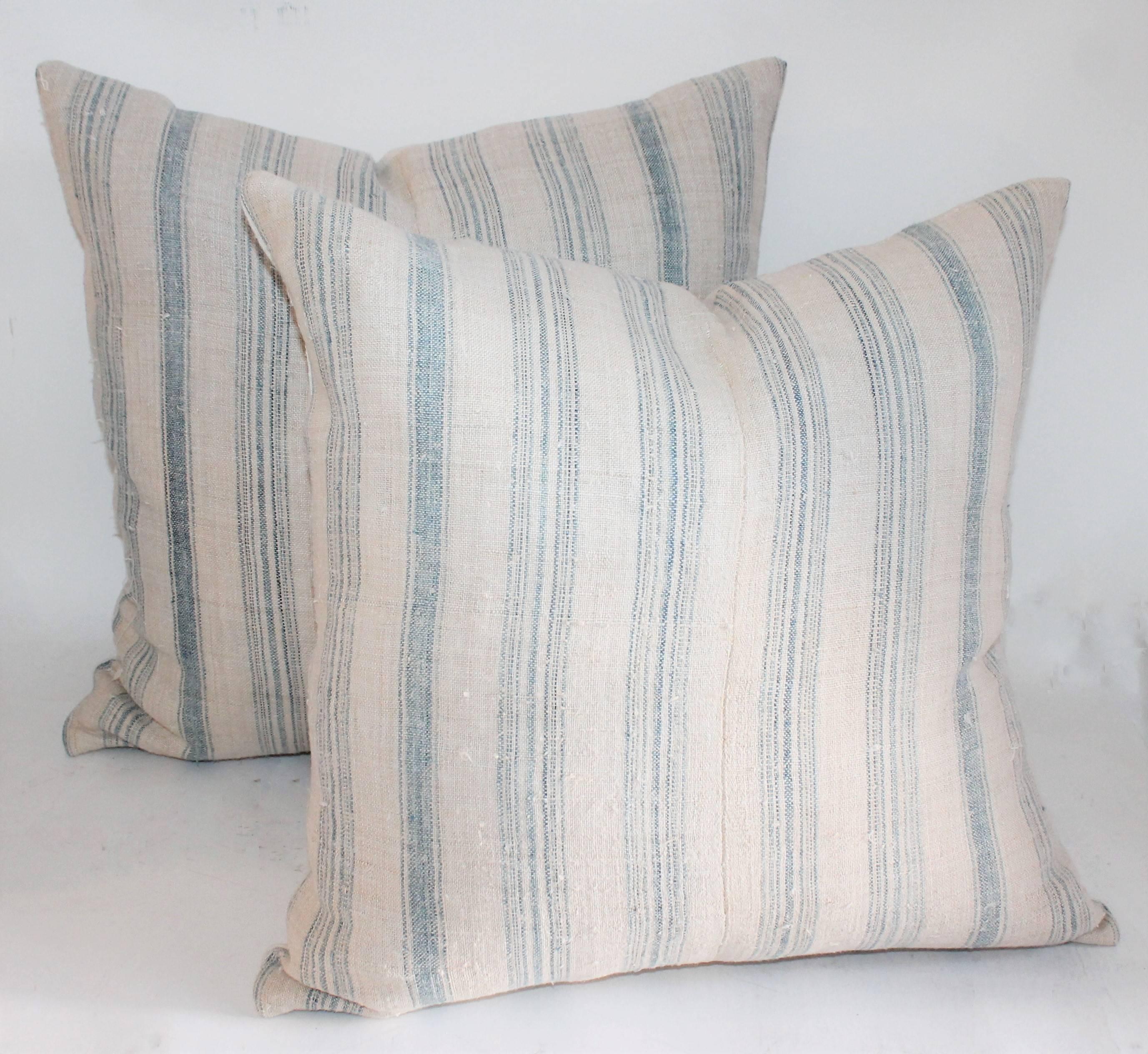 We have two vintage pairs of light blue and white ticking pillows in great condition. This set of four pillows are professionally laundered and have been fitted with down and feather inserts. All pillows are made in house. Sold as a group of four.