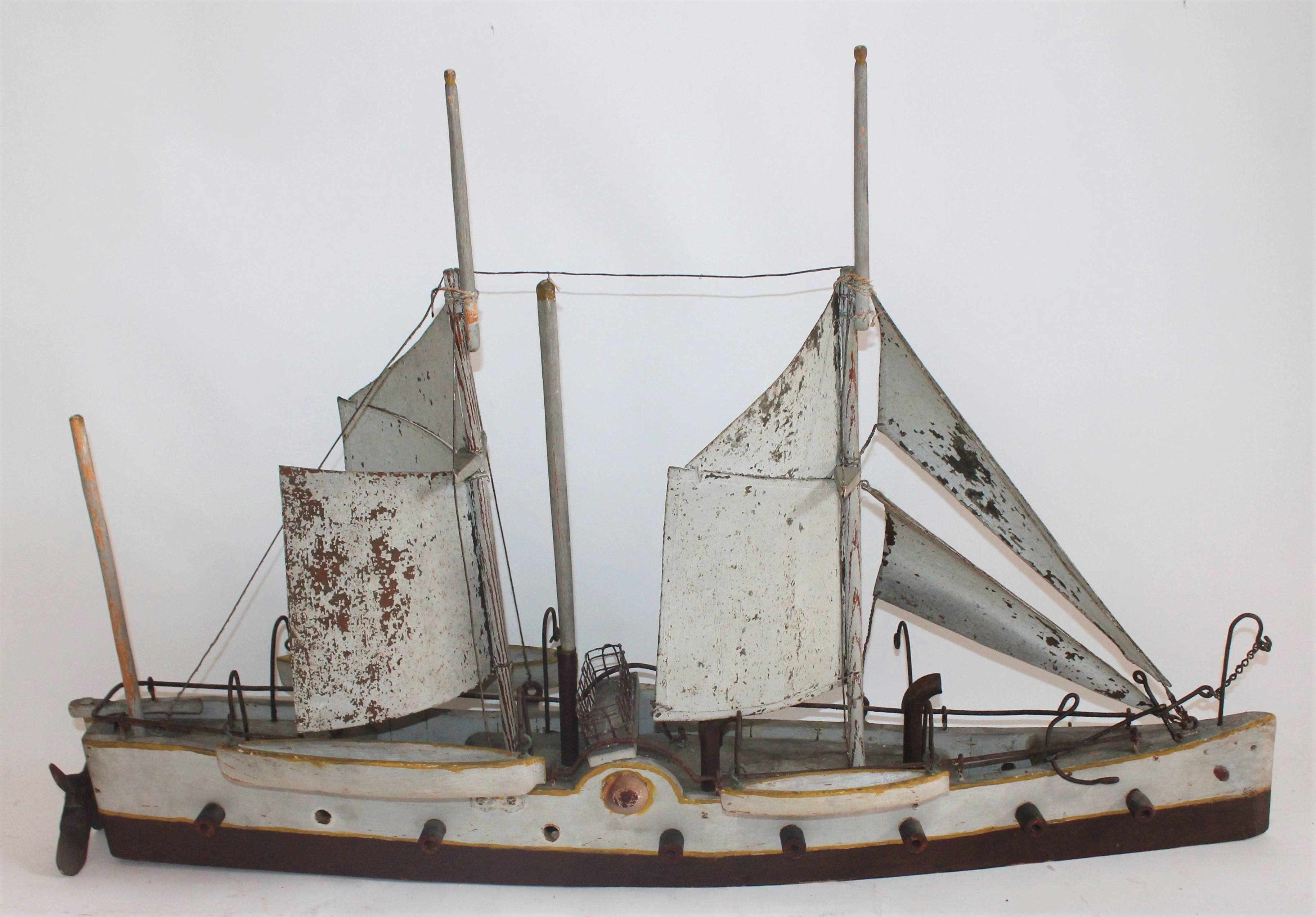 Early 20th century handmade and painted battleship boat found in the state of Maine. This fine folk art model boat was hand crafted vessel and has three life boats and the sides along with a handmade wire anchor on the front right hand side. The