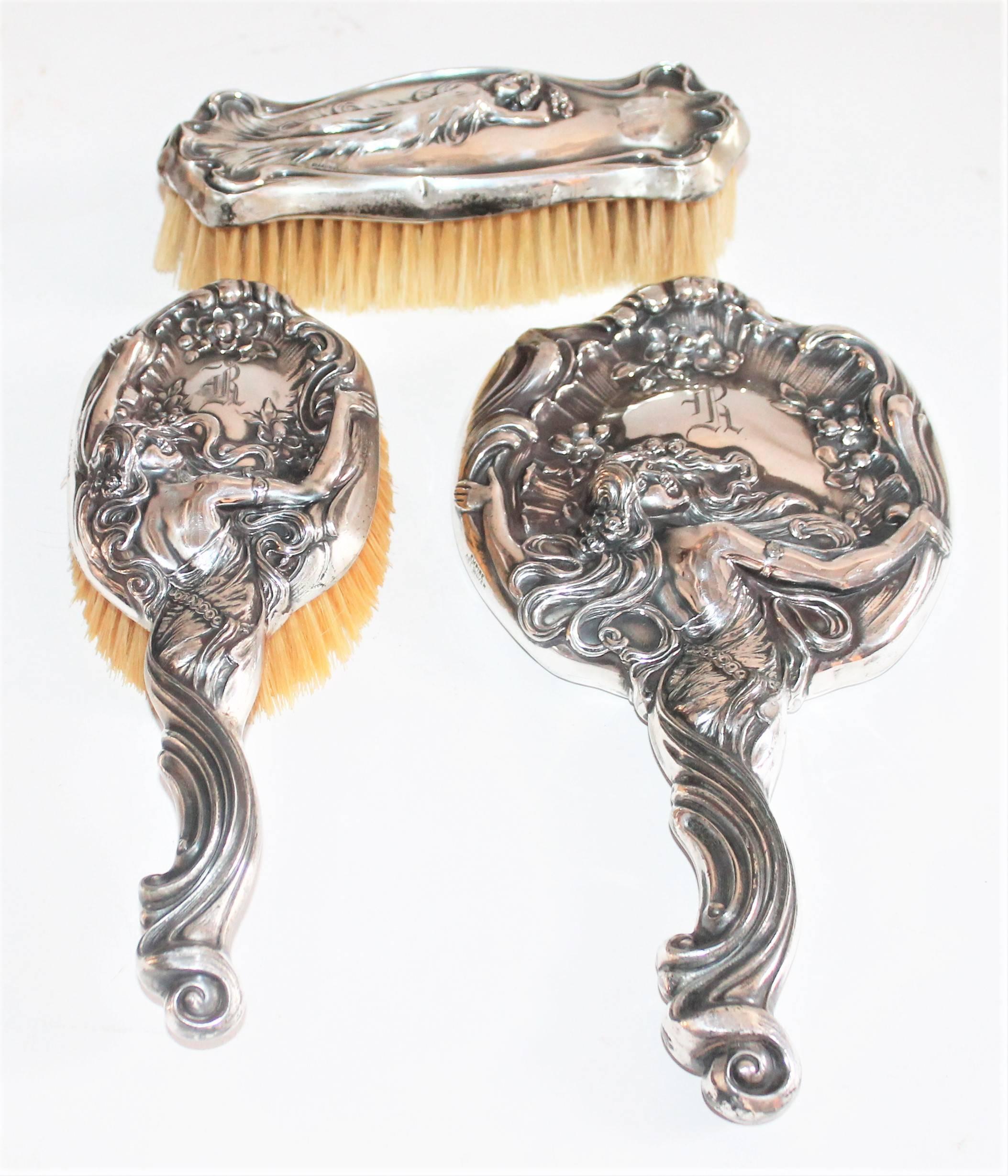 Art Nouveau set of sterling silver embossed brush, comb and mirror. With initial R engraved on them. Empire Art Silver. Dated May 24, 1904. 

Measures: brush 7in x 2.5in x 2in
comb 9in x 3.5in x 2.5in
mirror 10.5in x 1.5in x 5.5in.