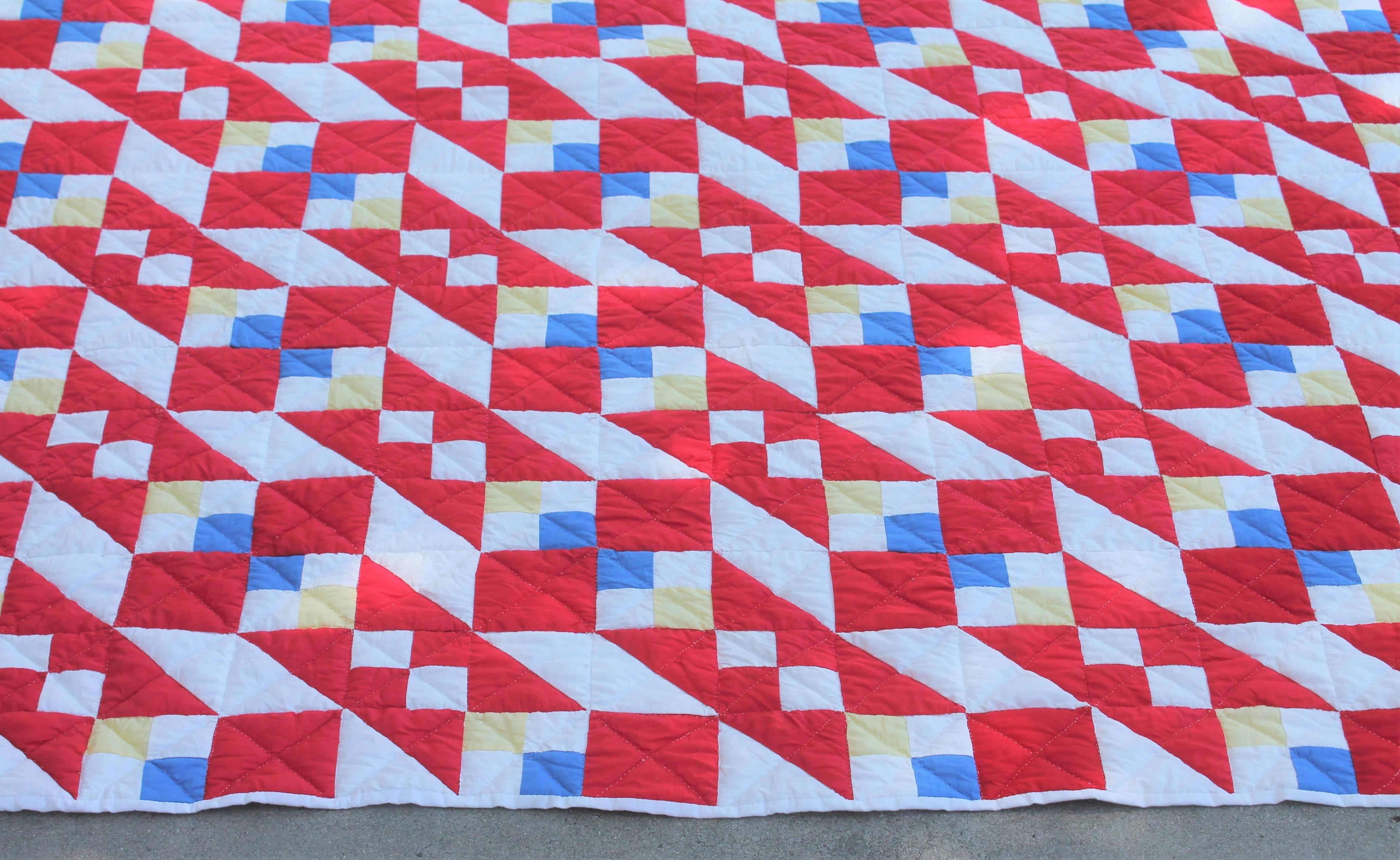This geometric red, white and blue quilt has small blocks of yellow squares with in the pattern. The condition is very good as well as the quilting is nice and tight.