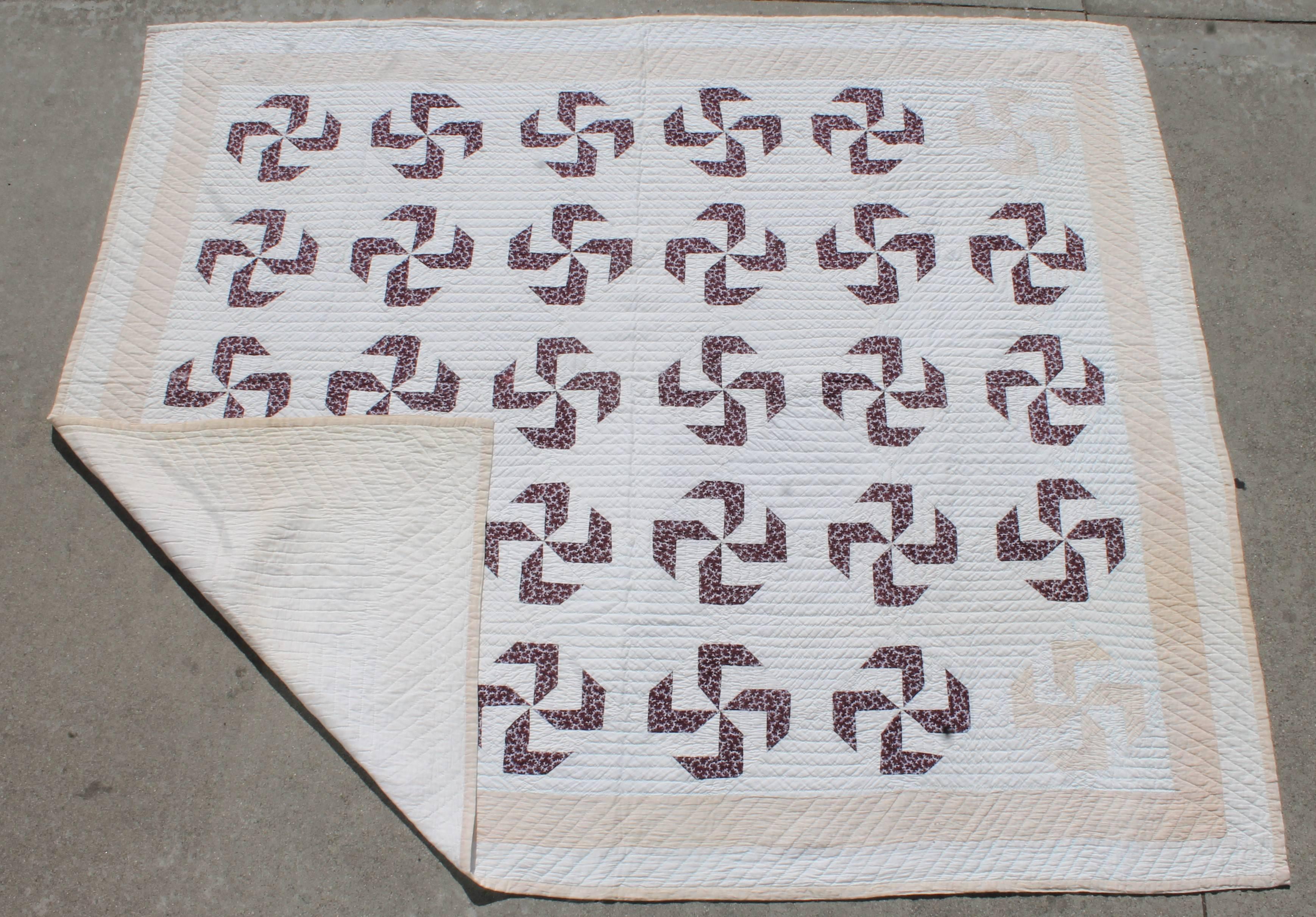 This 19th century fly foot pattern quilt is in brown calicos and has wonderful tight stitching. The inner border is tan and the two corner whirling logs are in the tan fabric. The condition is very good.