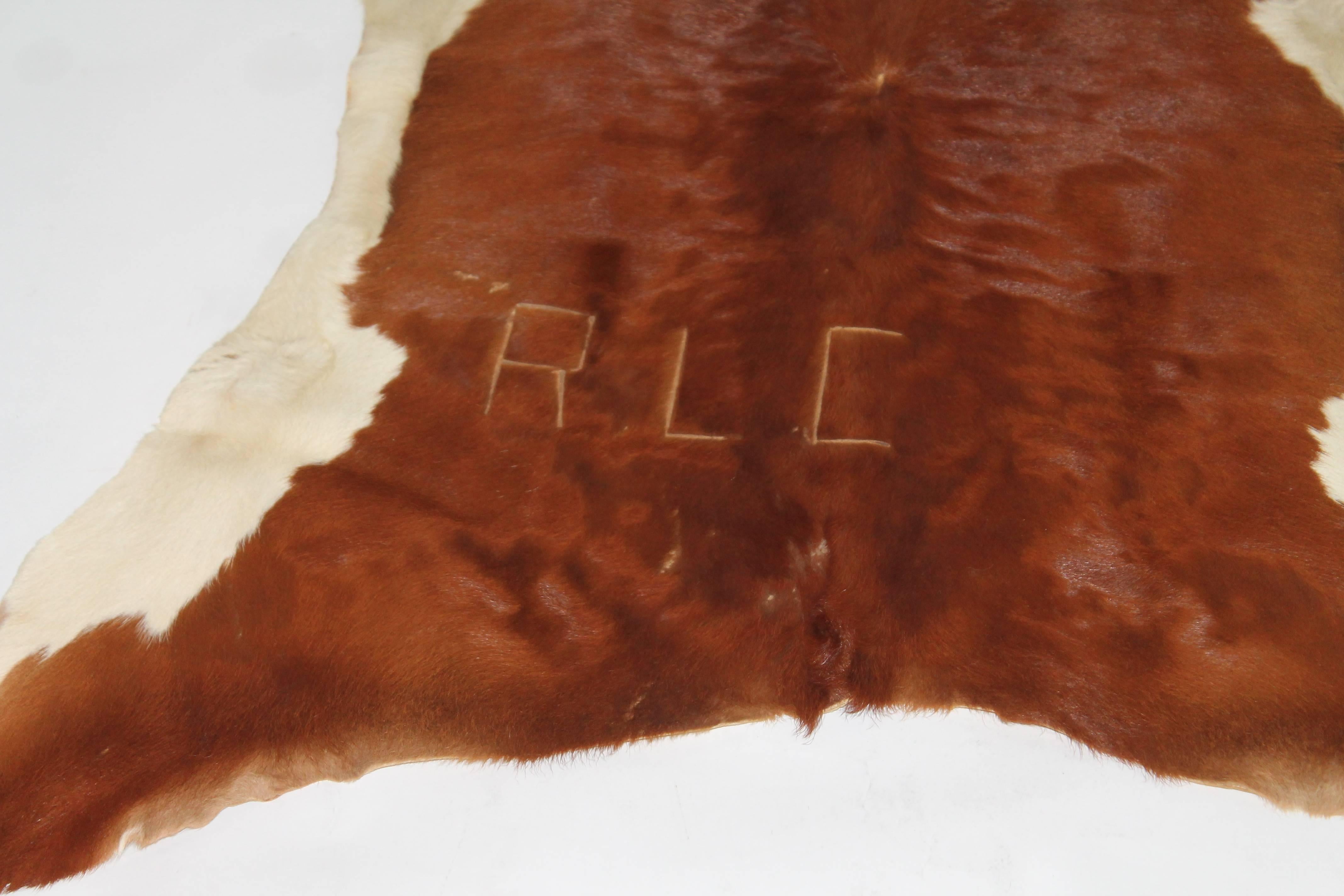 This Fine little calf skin rug is vintage and has branded letters 