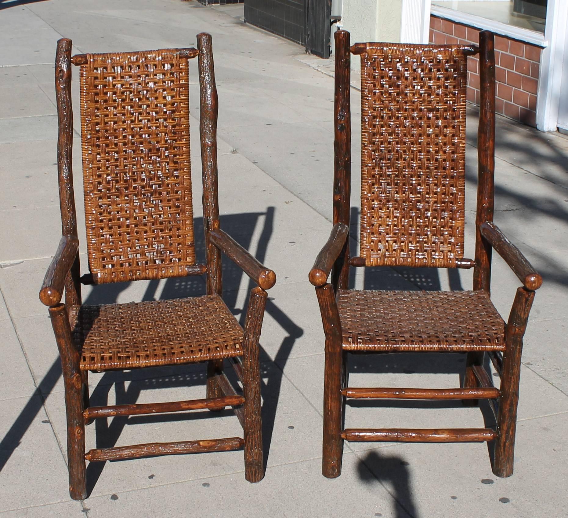 Pair of signed Old Hickory Furniture Co., Martinsville, Indiana high back armchairs. These chairs have the original hand woven seats and backs. The condition are very good and sturdy. There are also a set of six regular height Old Hickory dining