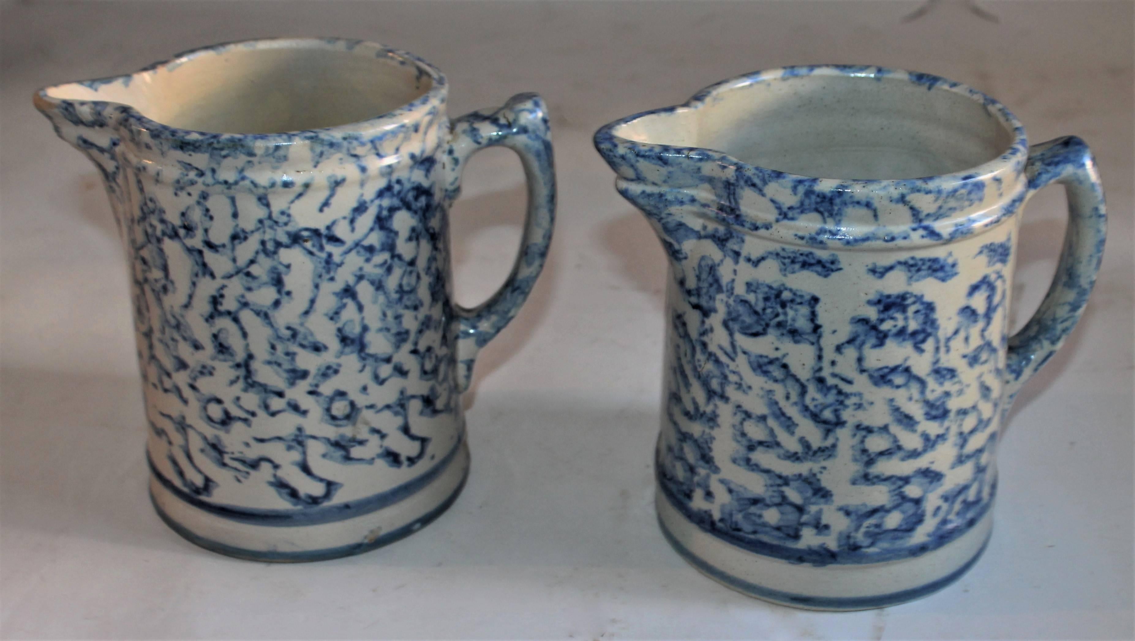 This pair of spongeware pottery pitchers are in fine condition and both have similar shapes. The blue is lighter in one from the other.