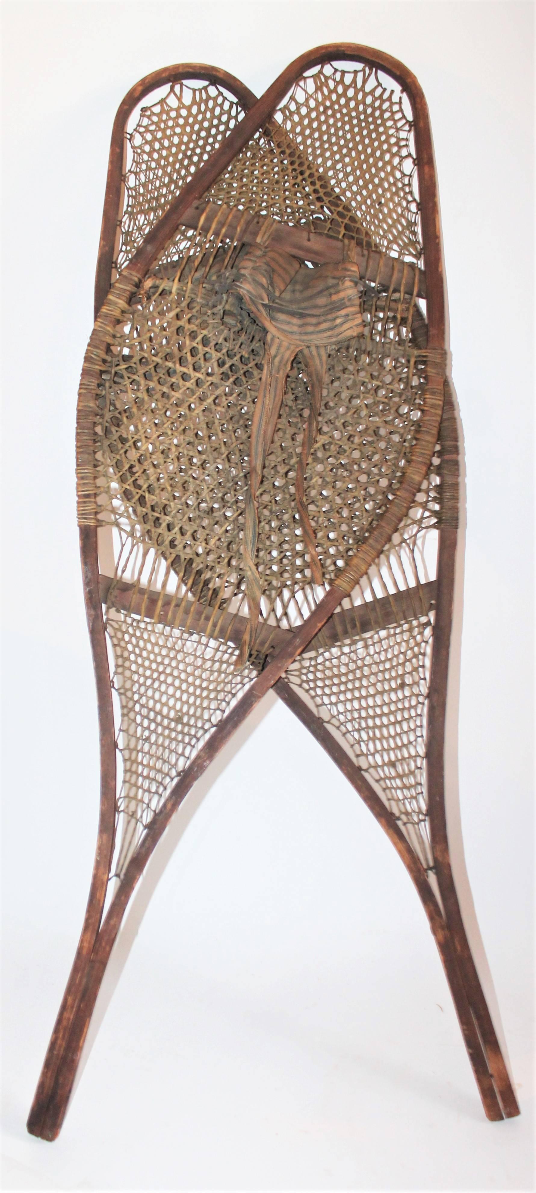 These amazing handmade rawhide and wood snowshoes were found in the State of Maine. Probably originally made in Canada. There are fabric / ticking ties in the center of these shoes.