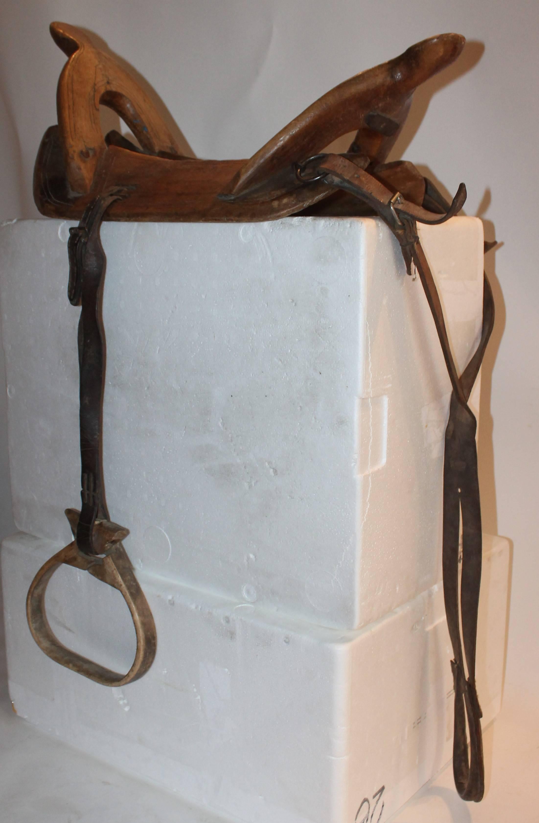 Cet ancien porte-selle en bois et cuir est en excellent état.