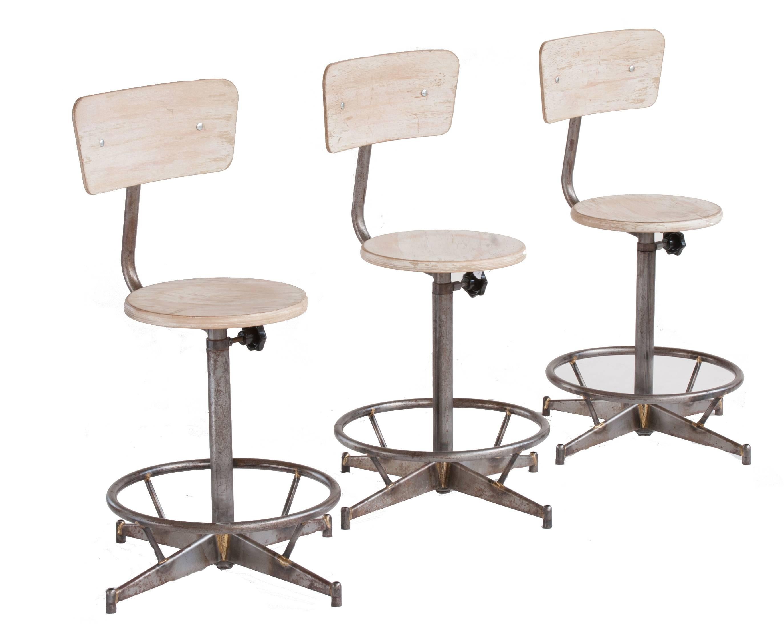 A light wood adjustable Industrial swivel stool with back.