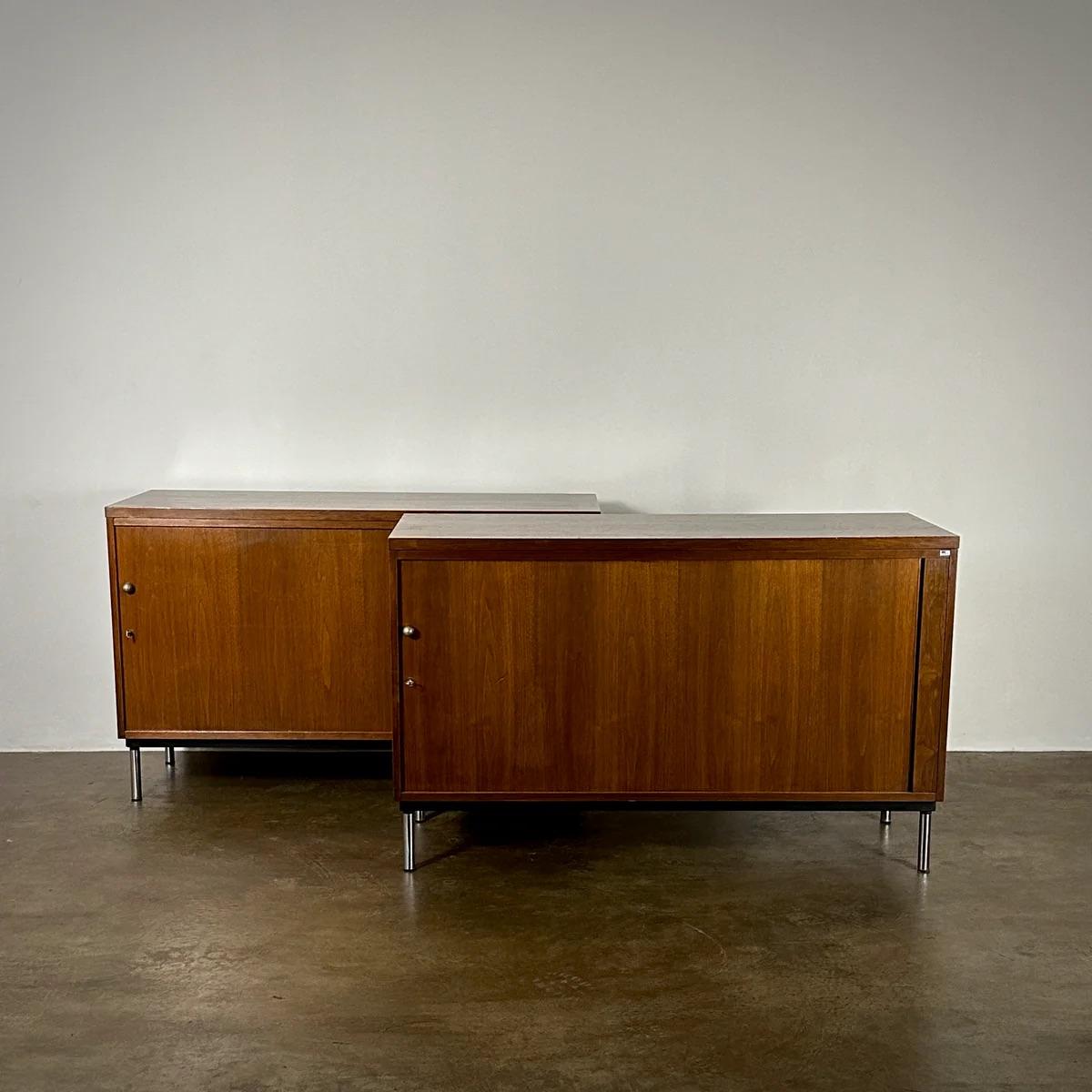 Pair of Dutch 1970s walnut wood sideboards or large nightstands featuring sliding doors set on slim chrome legs. These pieces embody sophisticated mid-century elegance with a grounded yet lightweight feel, offering versatility and a streamlined