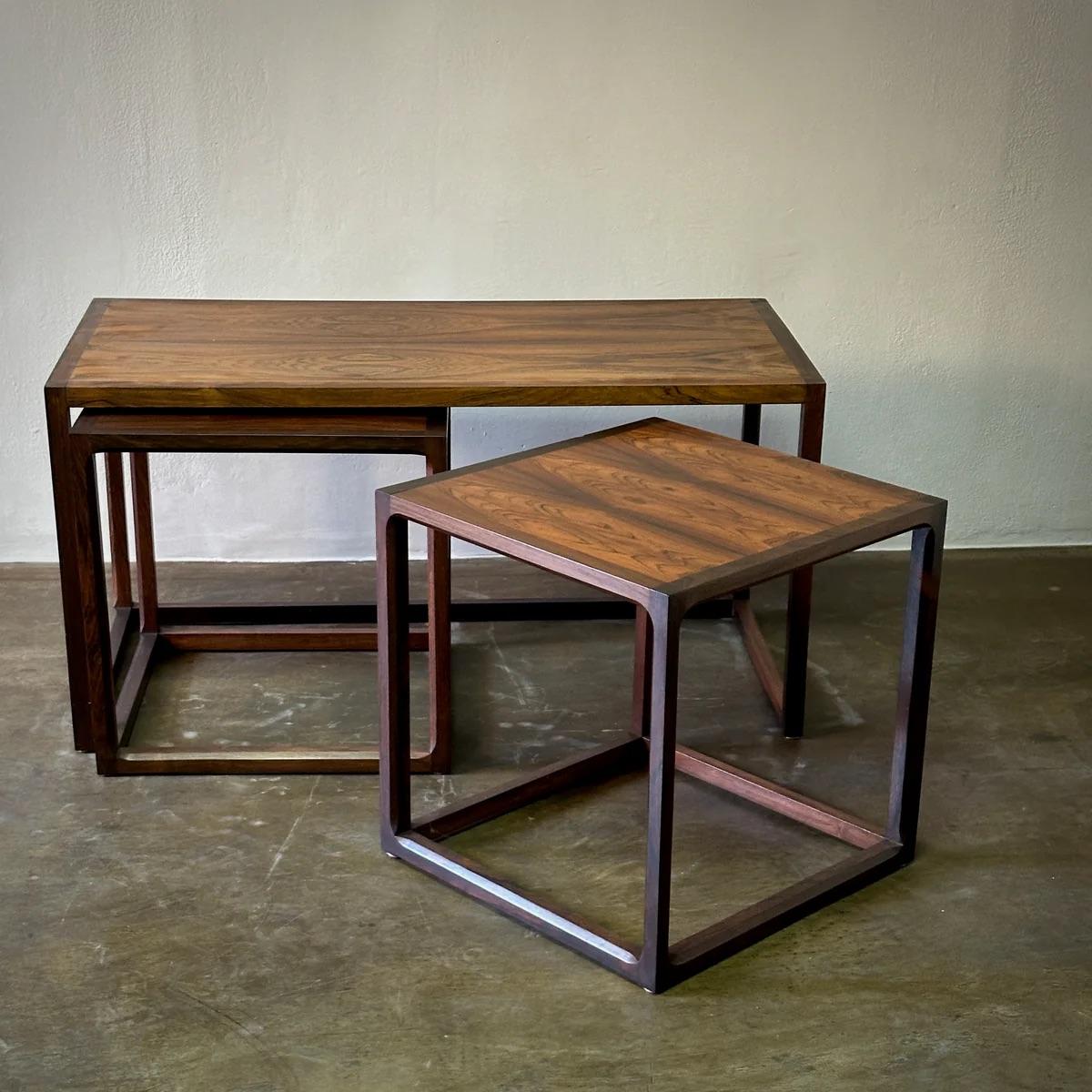 Cet ensemble exquis de tables d'appoint gigognes d'Askel Kjaersgaard, fabriqué en bois de rose, capture la quintessence des lignes épurées et de la beauté fonctionnelle du design danois. La grande table basse et ses petites compagnes s'intègrent