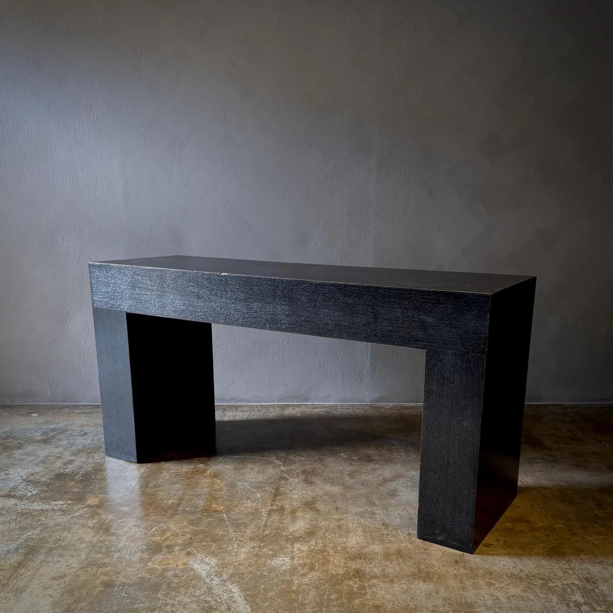 This sleek Belgian piece exemplifies minimalist elegance with its pure, stark lines and a deep black finish that absorbs light and attention alike. Perfect for showcasing statement accessories, this console blends seamlessly into contemporary décor