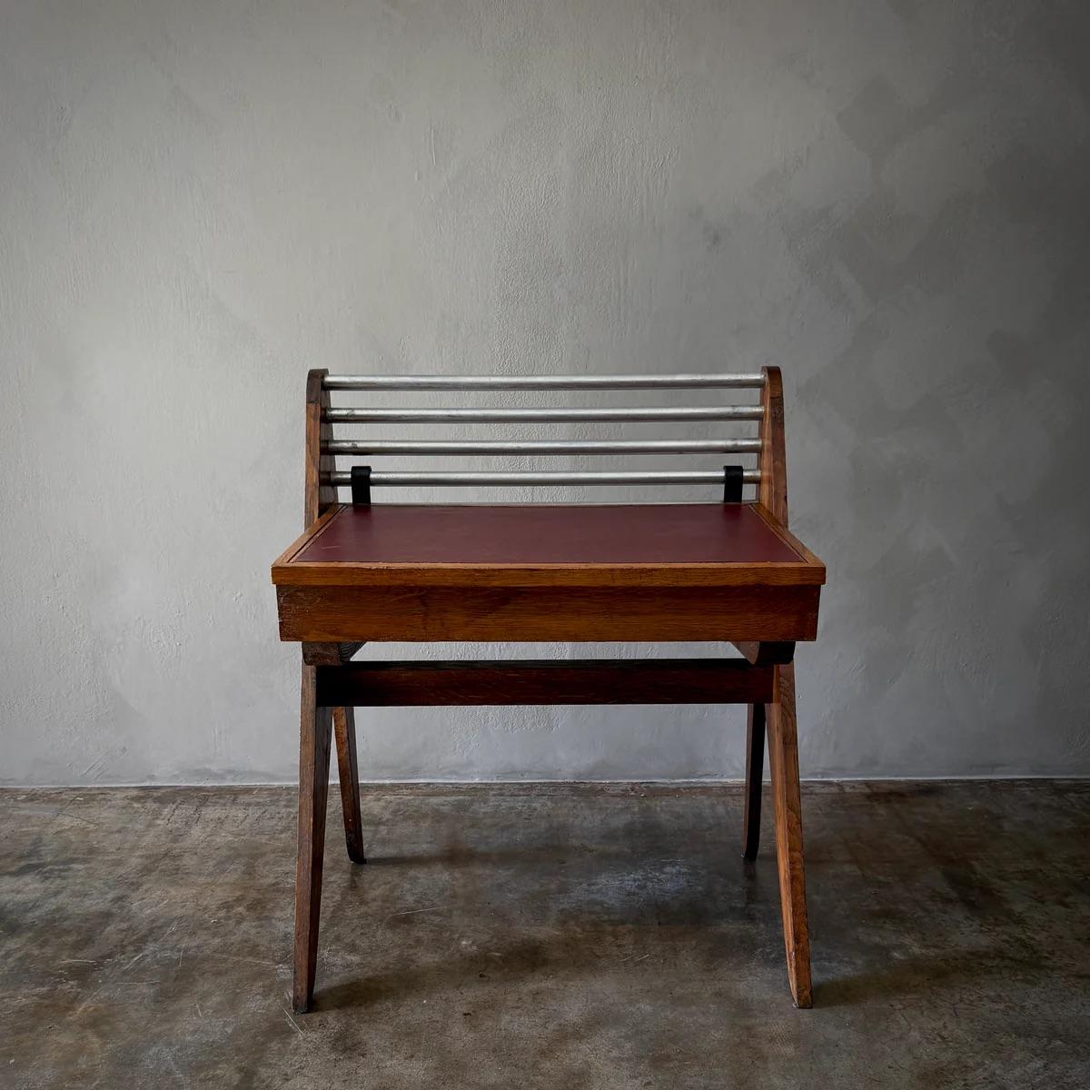 Ce bureau, attribué au designer français Robert Paveau, présente un mélange harmonieux de matériaux et d'éléments de design emblématiques du mobilier français du milieu du XXe siècle. Son design ajustable et la qualité de l'artisanat soulignent