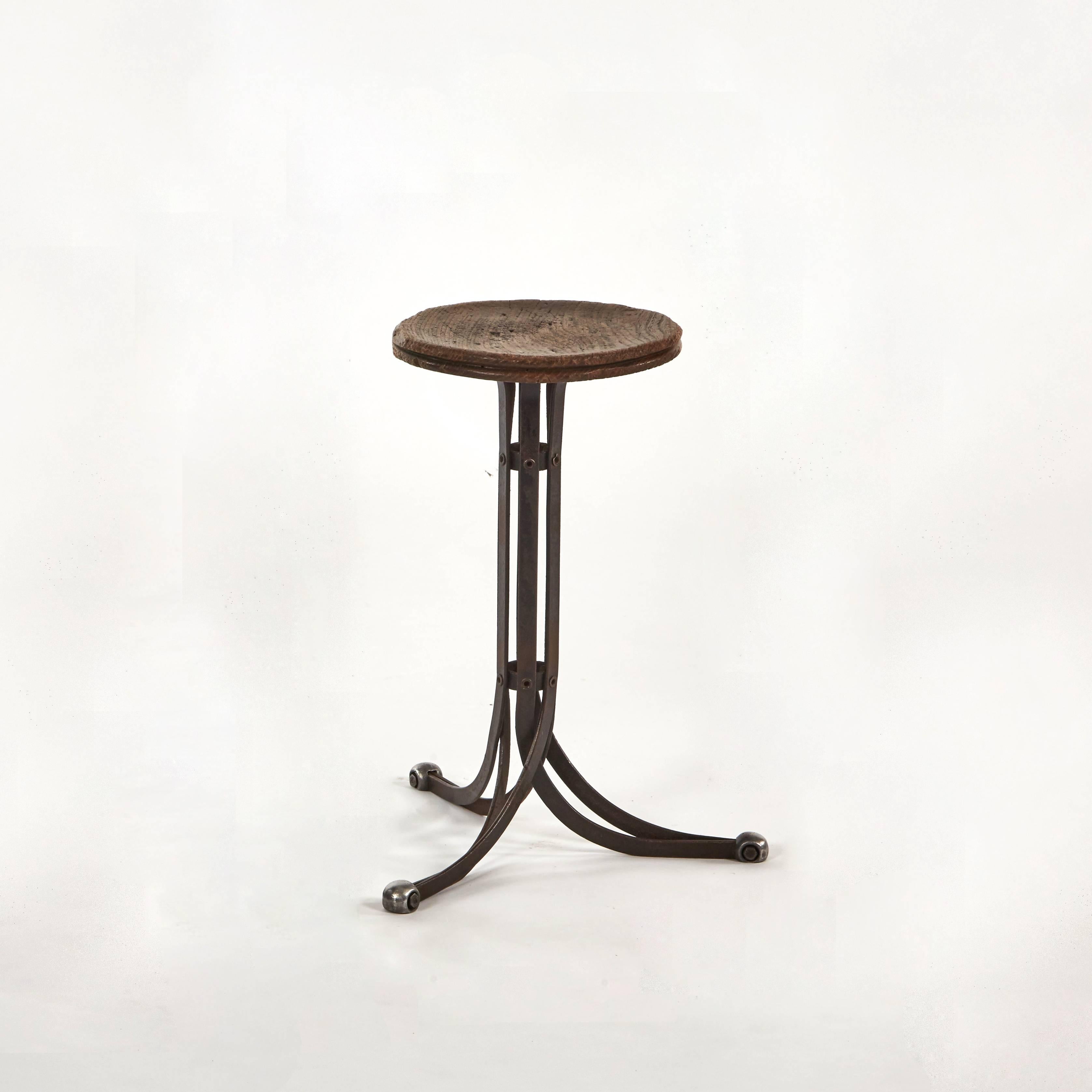 An Industrial stool with metal tripod base.