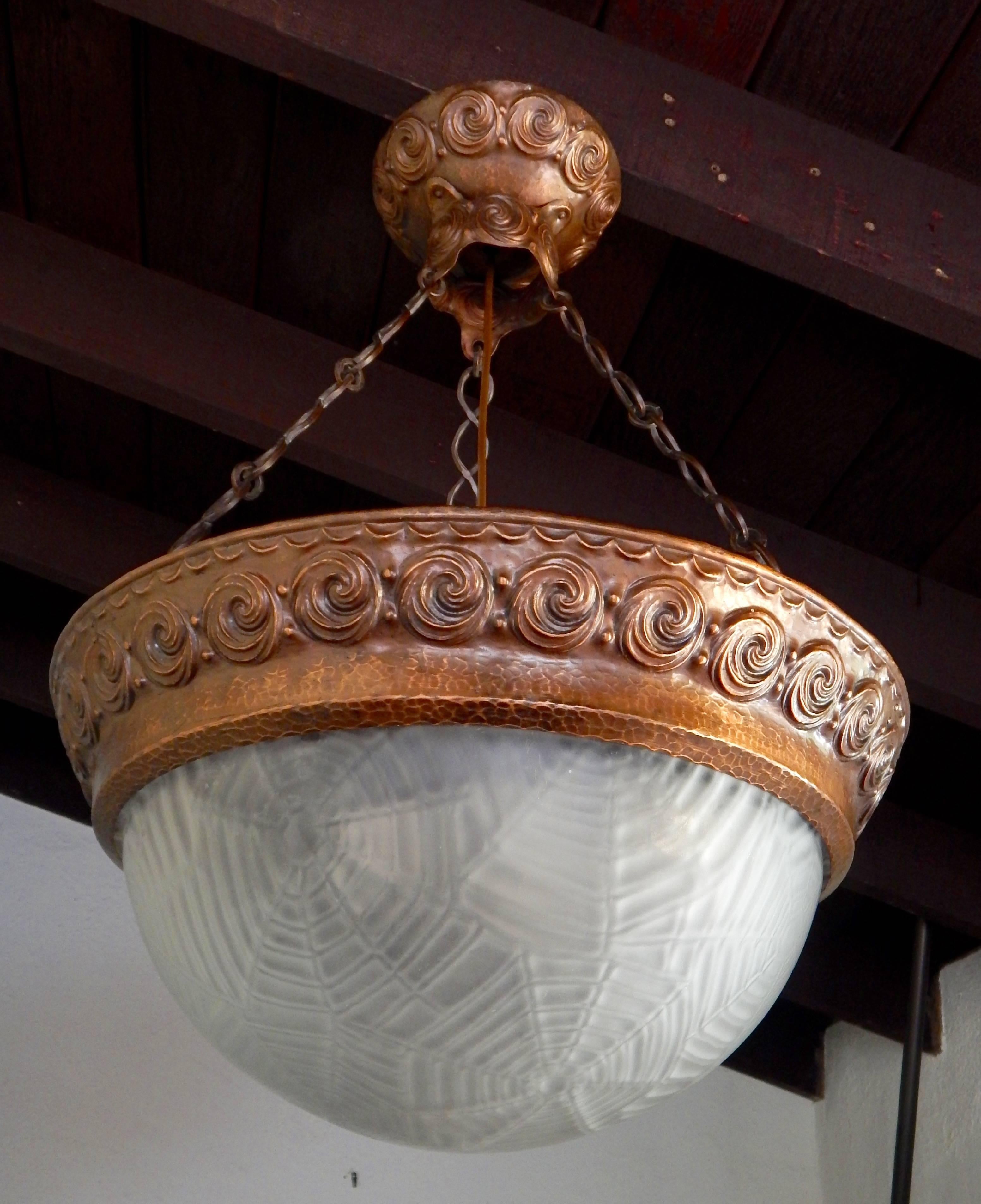 Swedish Arts and Crafts hand hammered copper hanging fixture, circa 1910. Original bowl shade in spider web pattern. Three bulb receptacles. Freshly rewired.